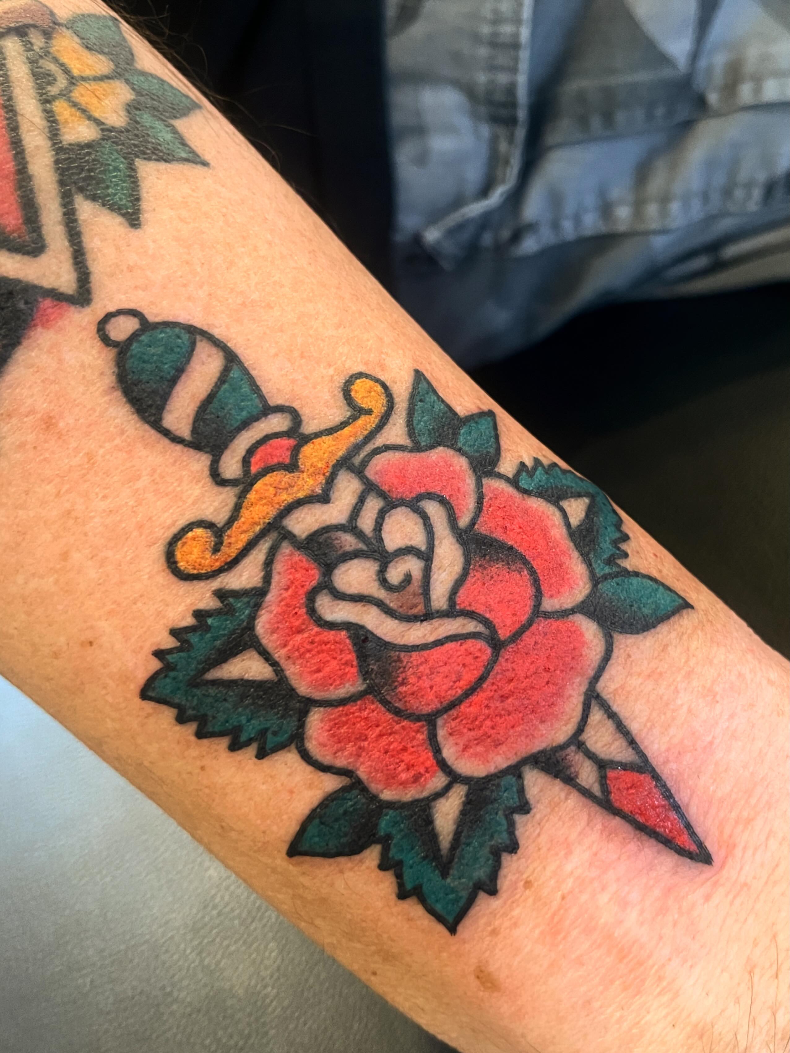 Rose and dagger American traditional tattoo on the forearm by Spencer Reisbeck