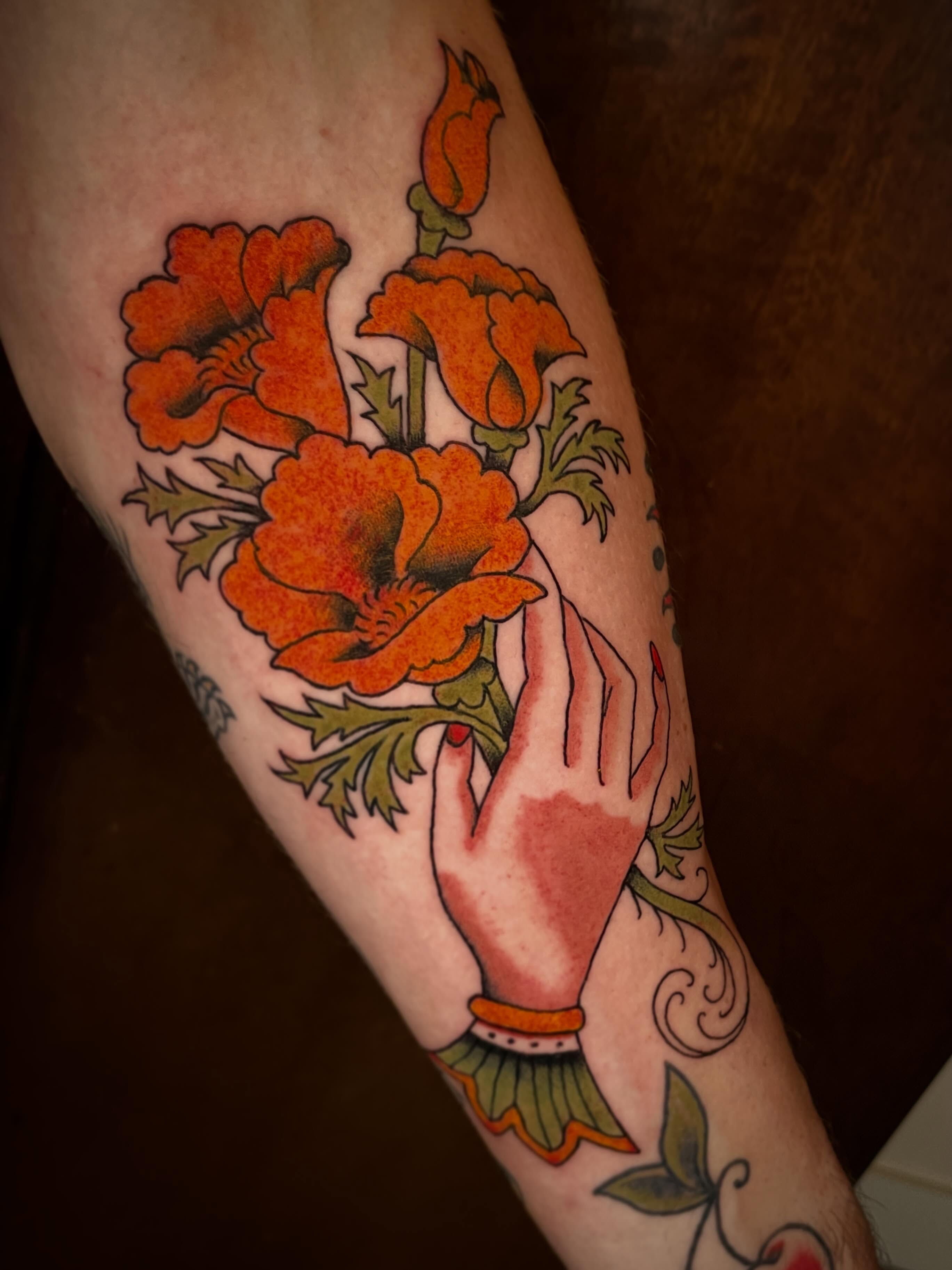Hand with flowers American traditional tattoo on the forearm by Nick Wallin