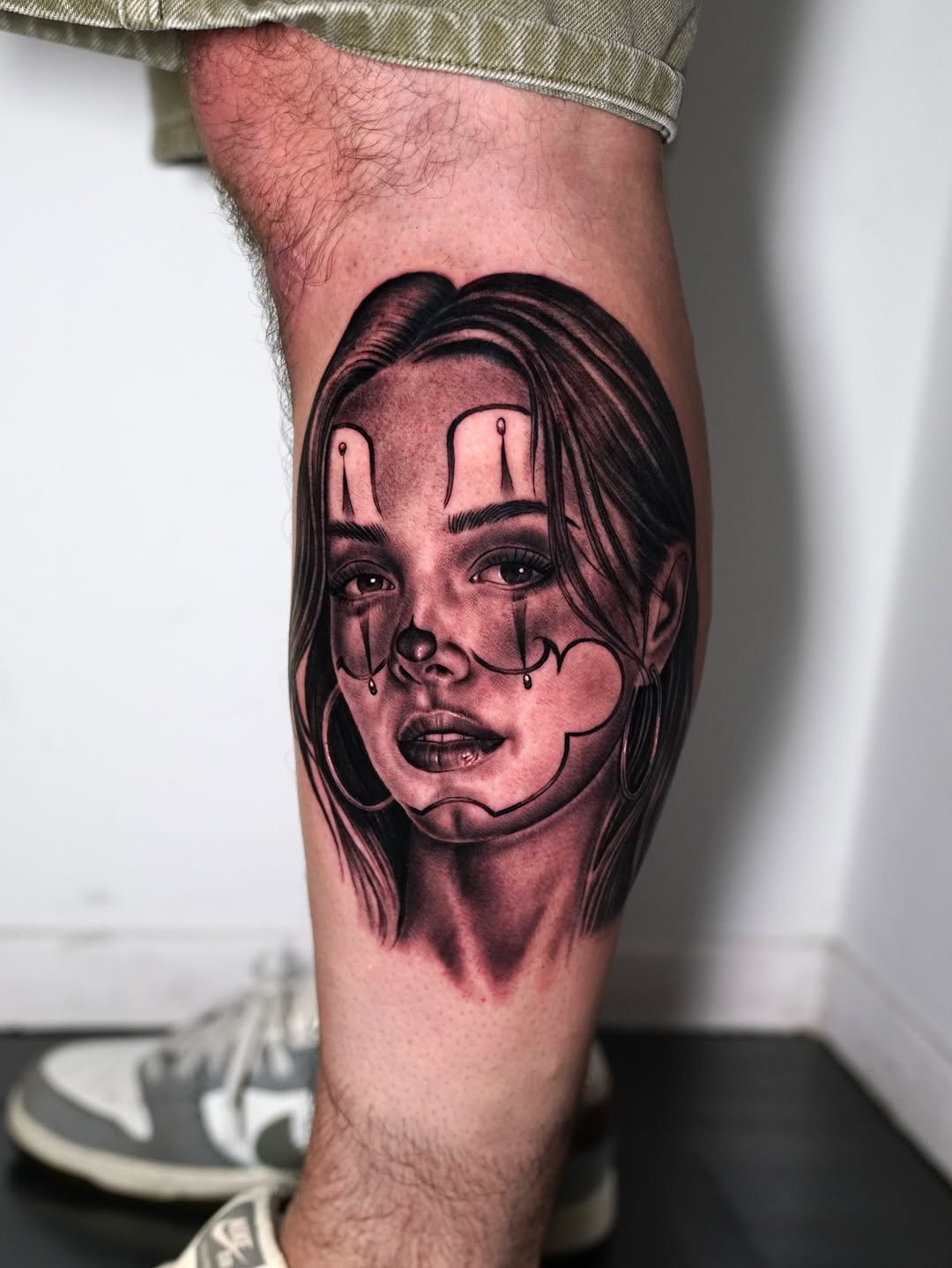 Woman's face with clown makeup Chicano tattoo on the forearm by Luis Peña