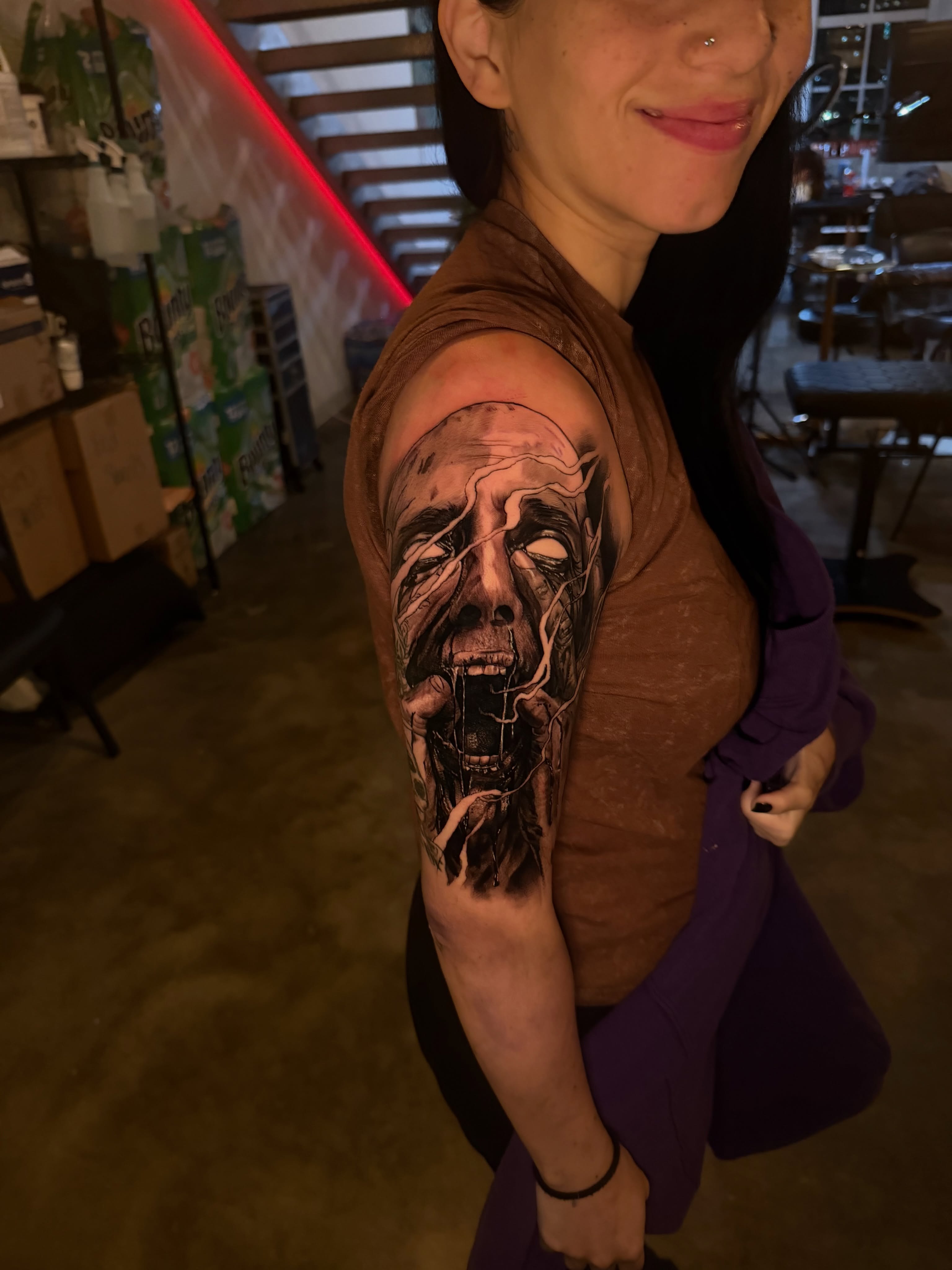 Horror face dark realism tattoo on the upper arm by Lemaih Gonzalez