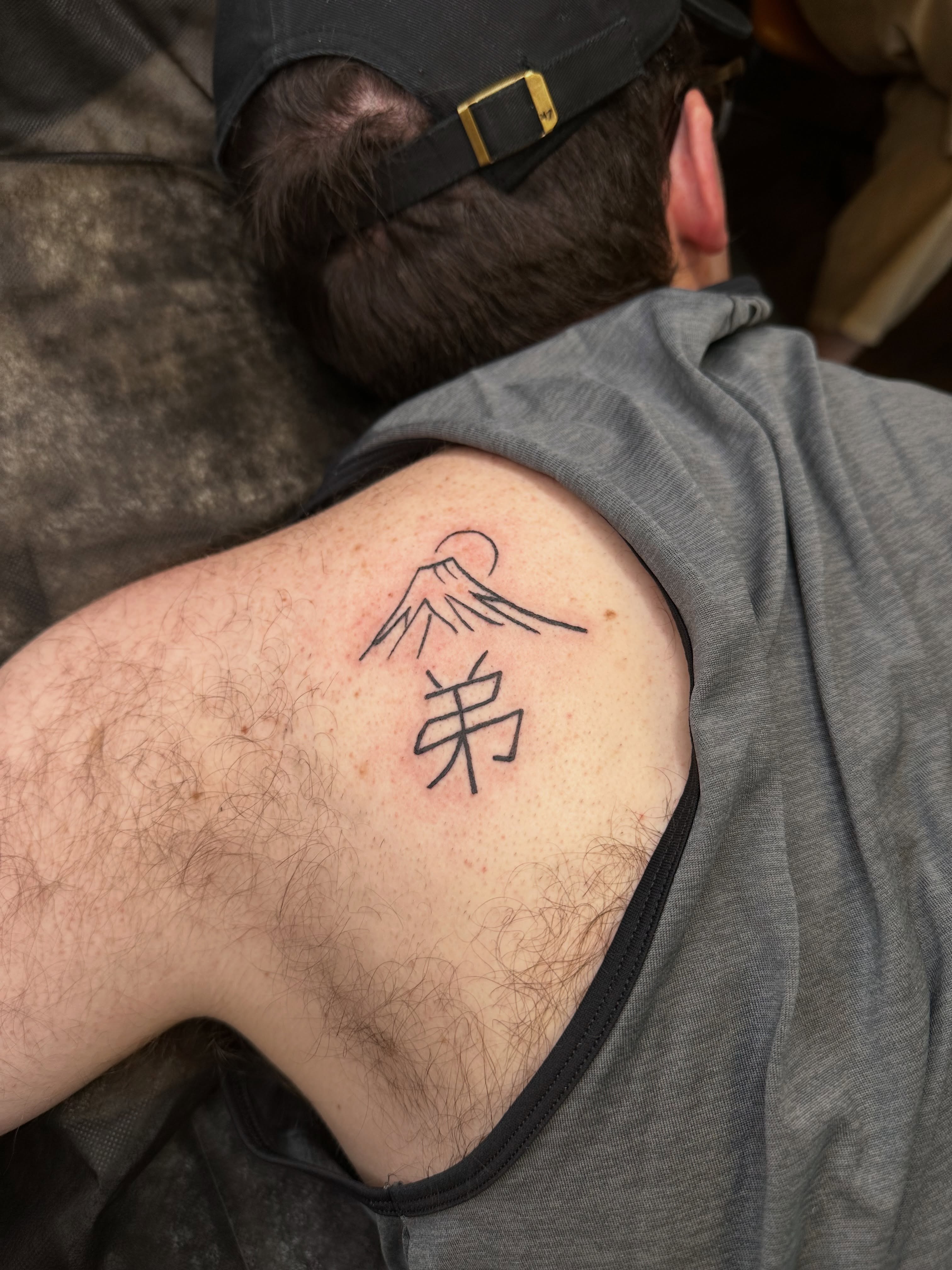 Mountain wave and kanji geometric tattoo on the back by Liz