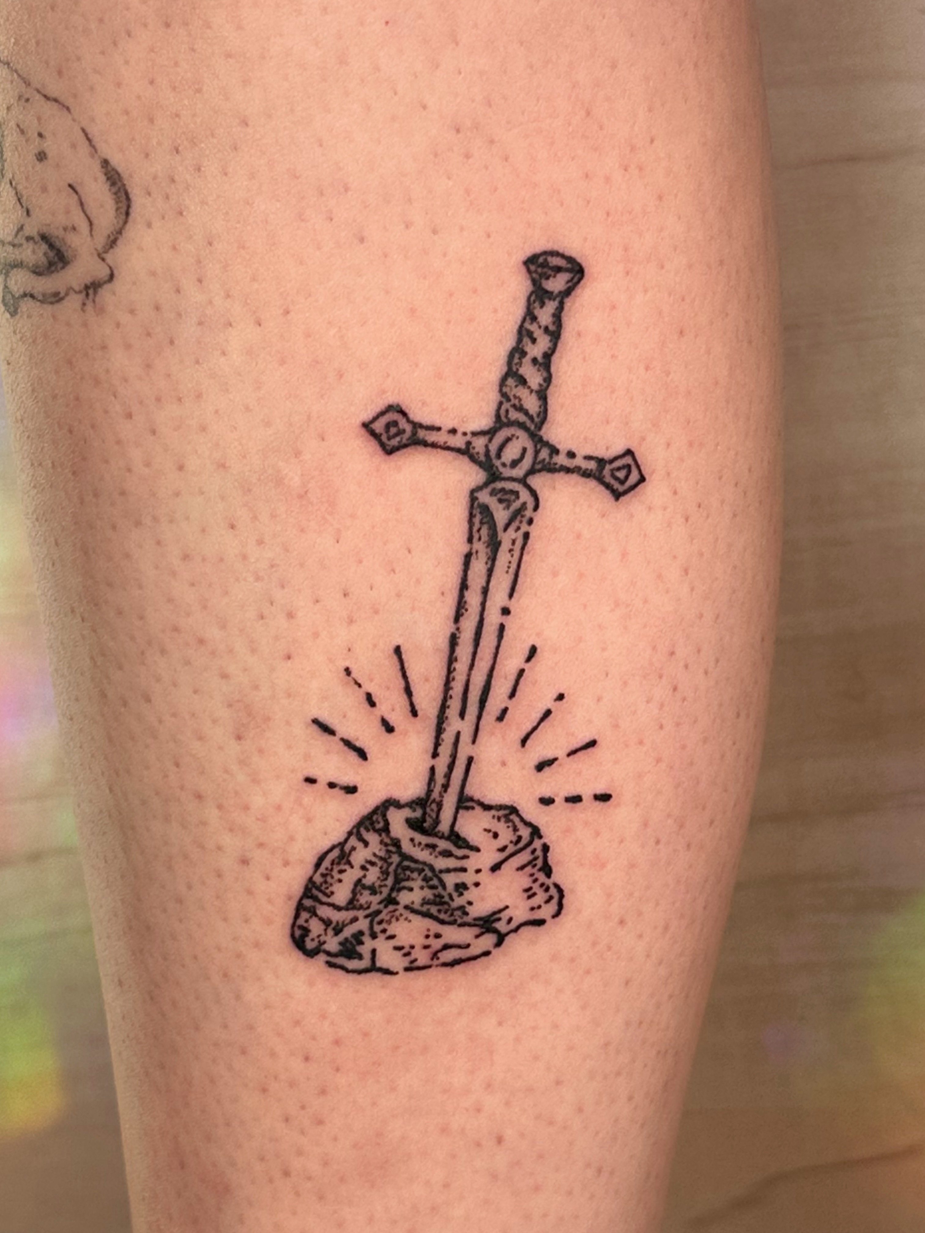 Sword in stone black and grey tattoo on the forearm by Fleur ๐ฅ