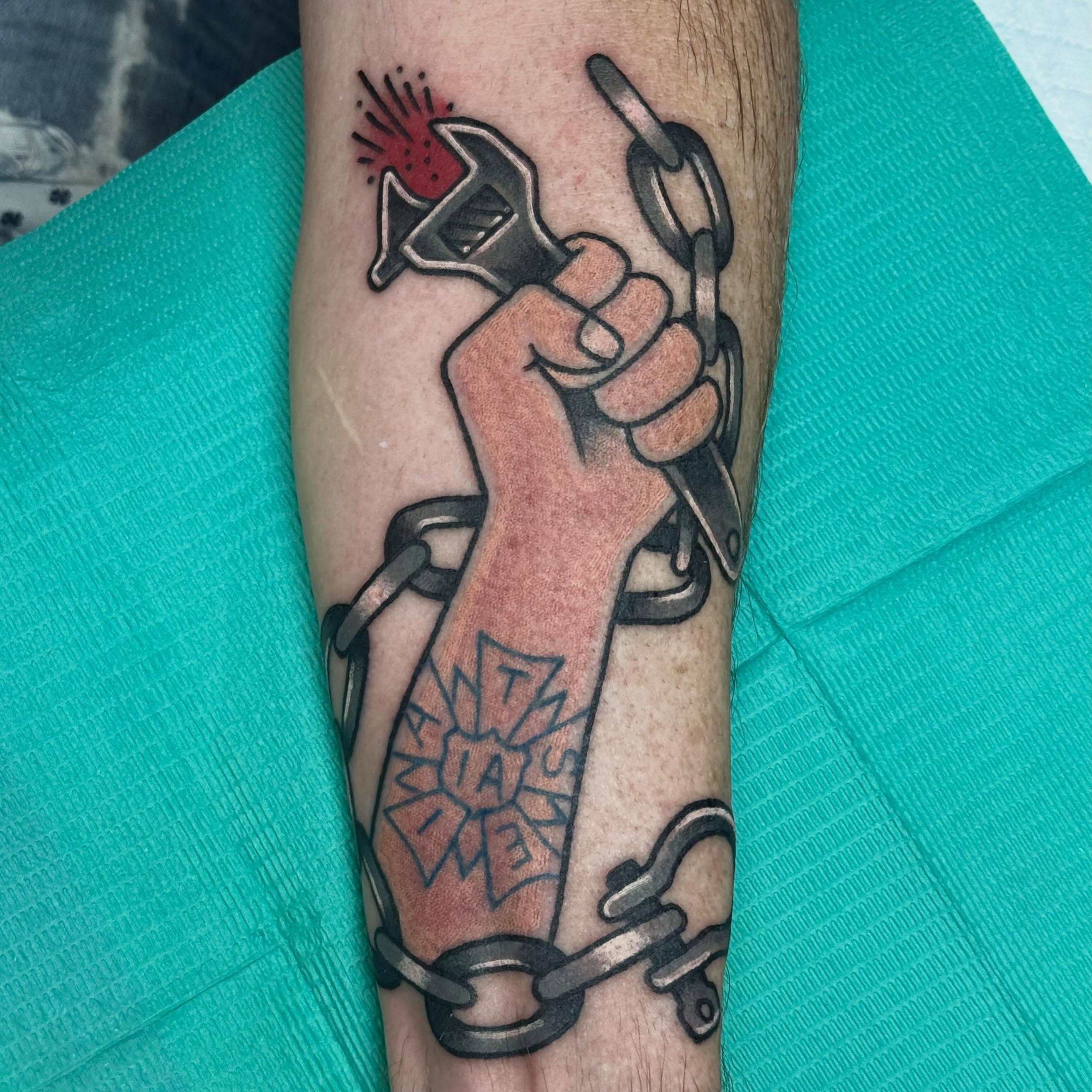 Fist breaking chains American traditional tattoo on the forearm by Timothy Kenee