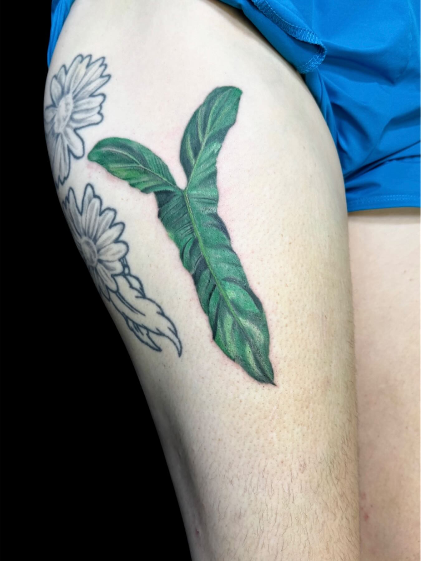 Banana leaf realism tattoo on the thigh by Cody Glenn