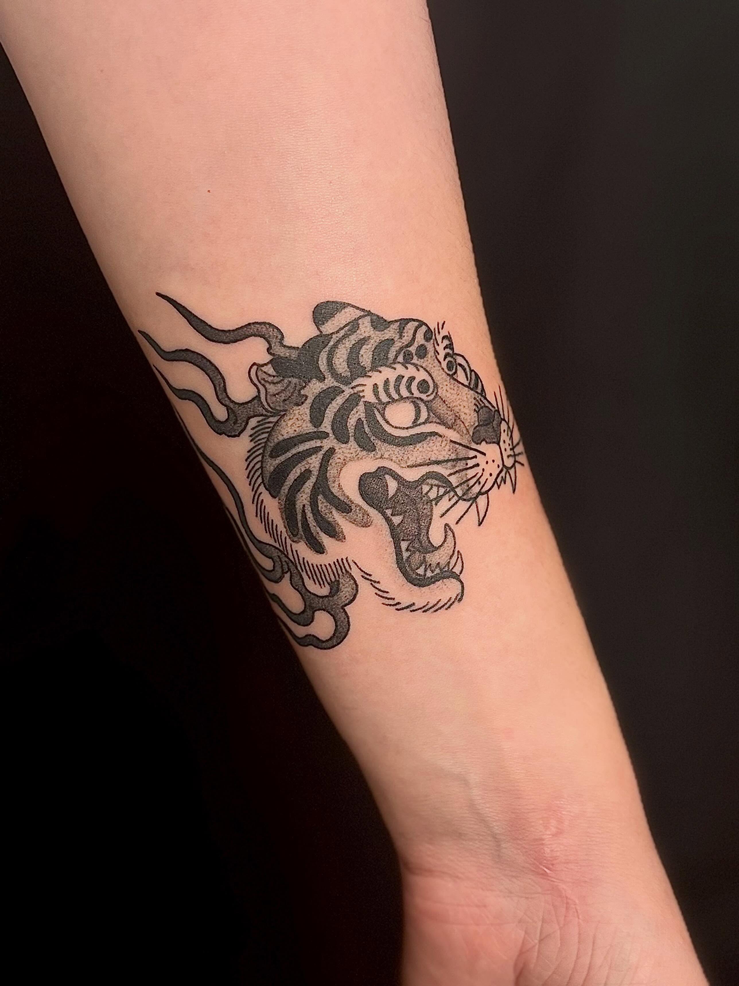 Tiger head black and grey tattoo on the forearm by Erica McCullough