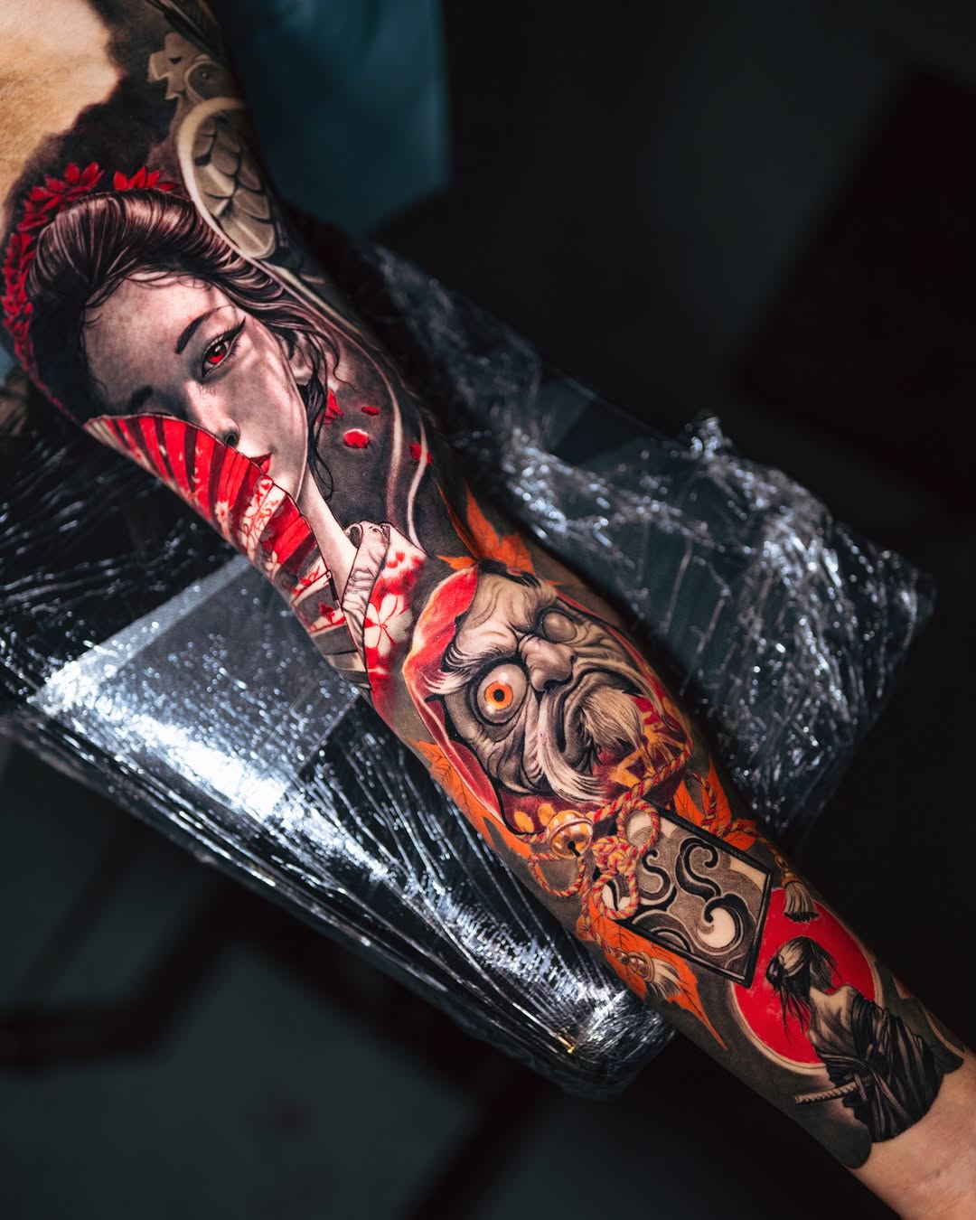 Geisha and oni mask Japanese tattoo on the forearm by Marcos Salamanca