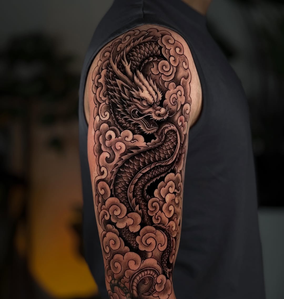 Dragon and clouds Japanese tattoo on the upper arm by Kai, Charlotte, North Carolina