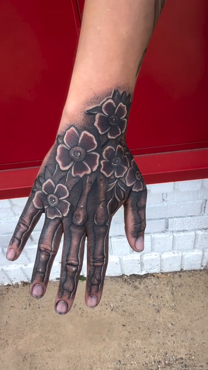 Skeleton hand with flowers realism tattoo by Alex Wheelock