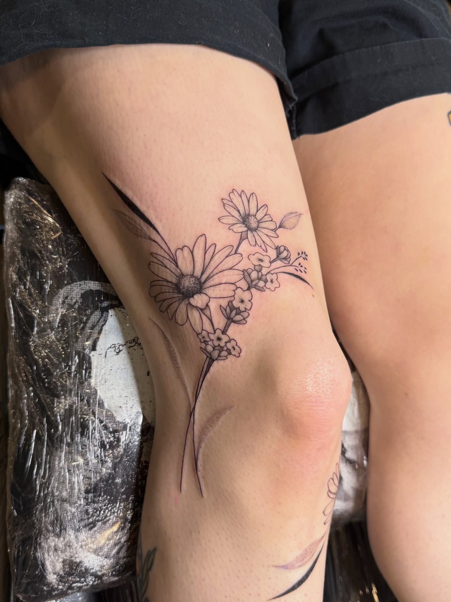 Daisies black and grey tattoo on the thigh by WhoisLaineyTattoos