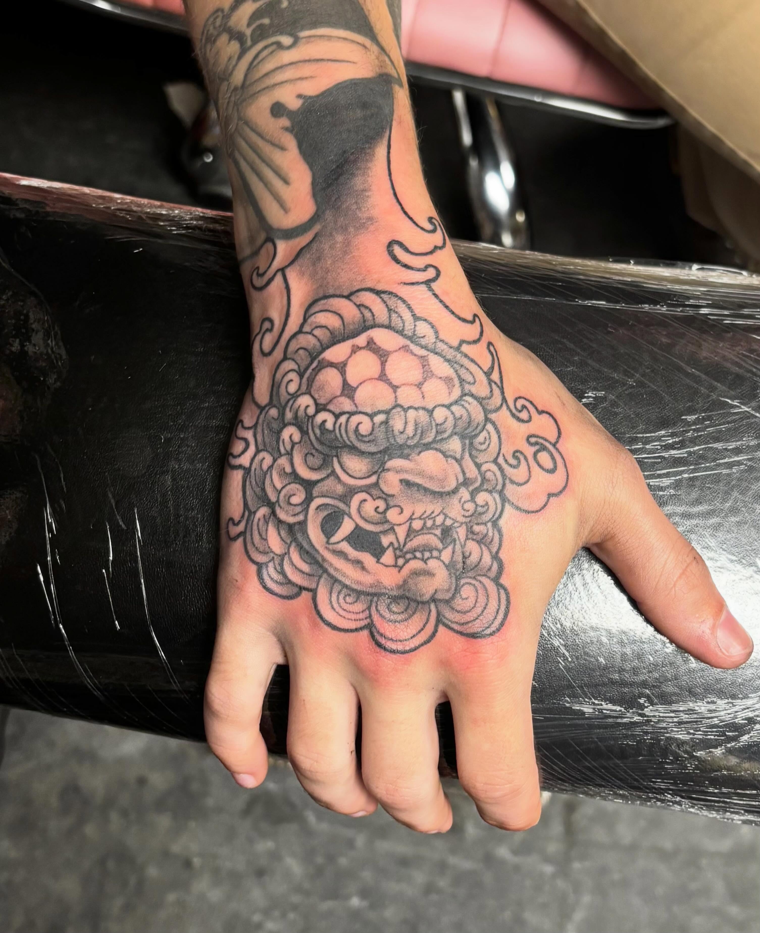 Lion head American traditional tattoo on the hand by Jeff Zuptich