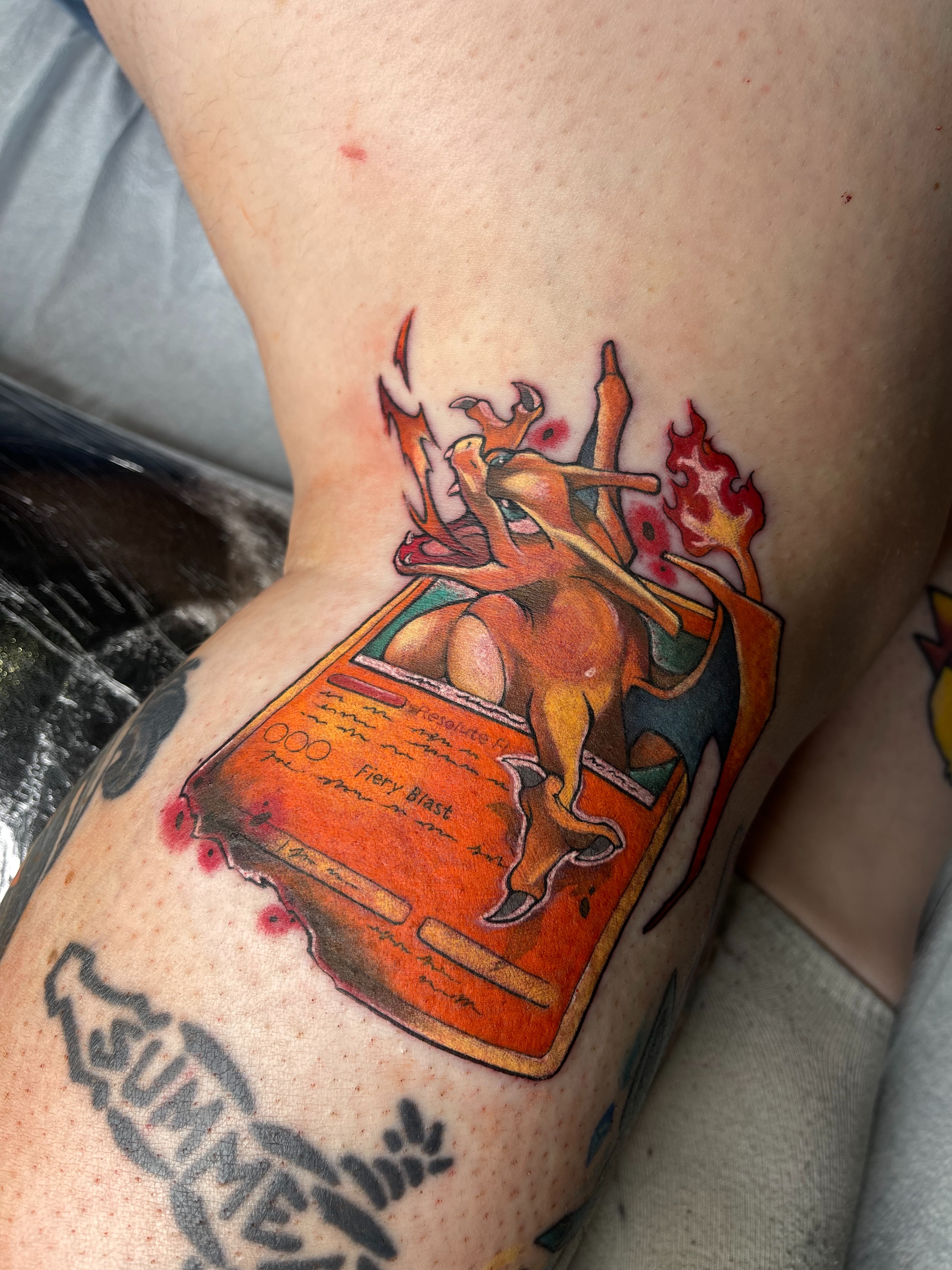 Charizard card illustrative tattoo on the thigh by Airi