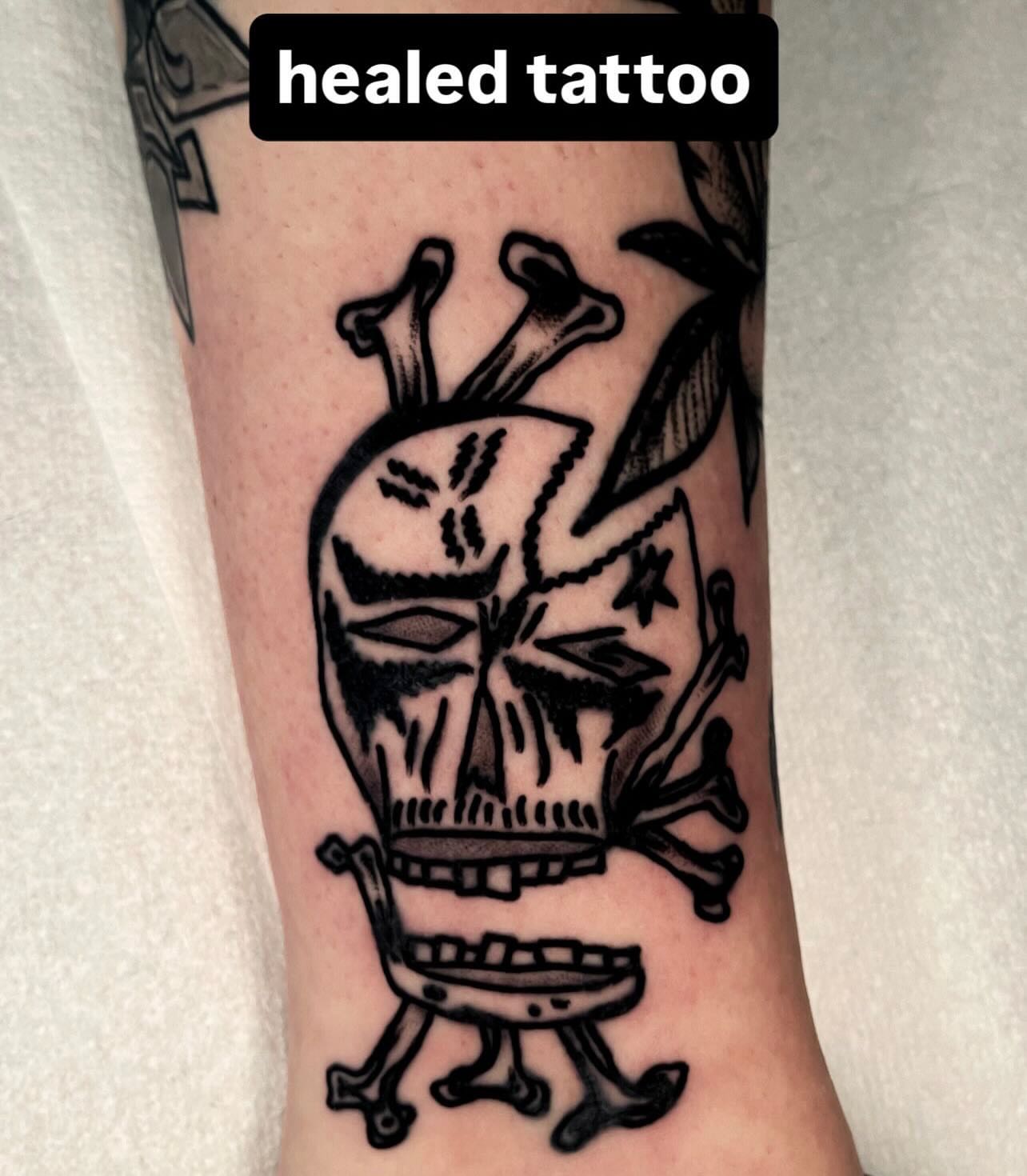 Skull with bones black and grey tattoo on the forearm by Devyn Hightower