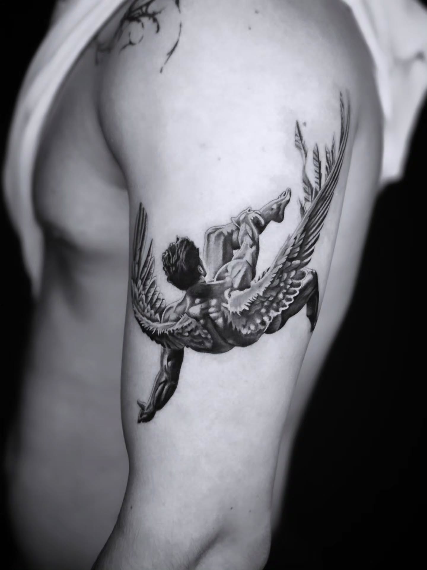 Angel falling realism tattoo on the upper arm by Jake Barney