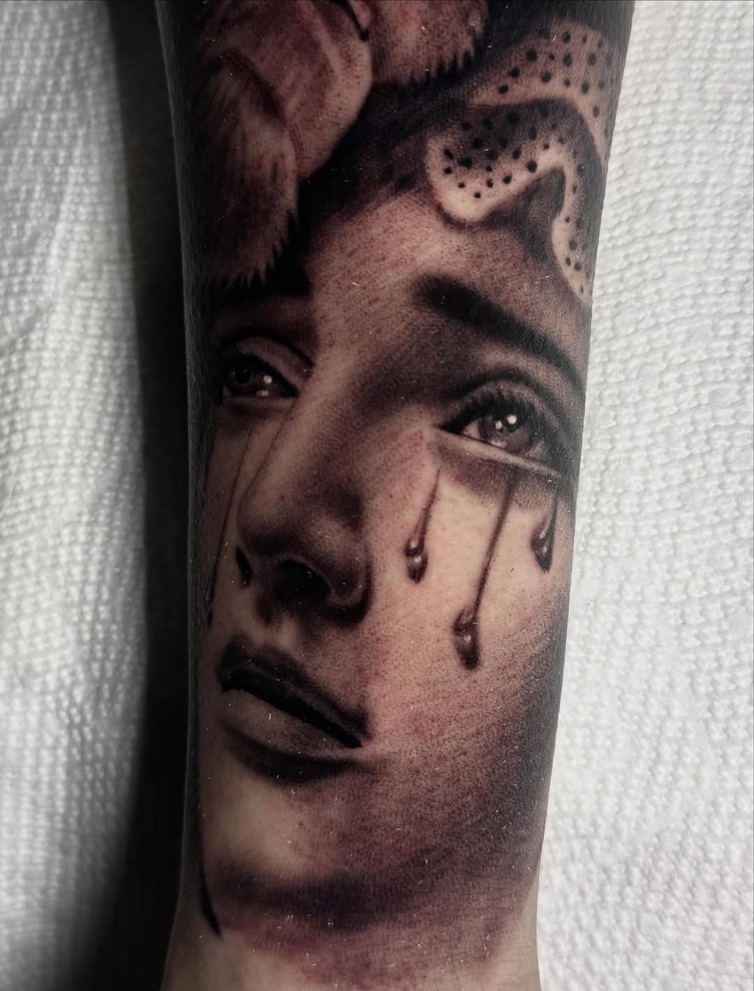 Crying woman's face realism tattoo on the forearm by Tony Garcia