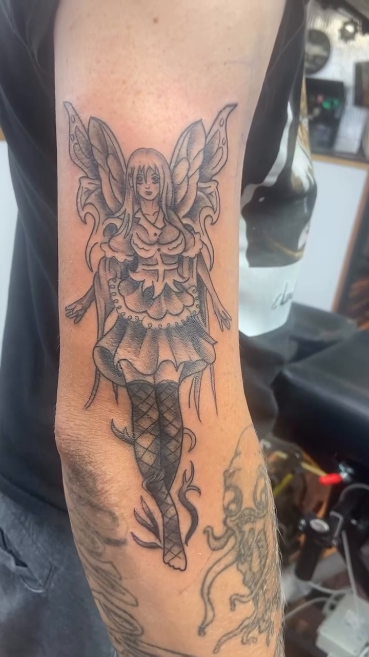 Fairy with wings and detailed dress fine line tattoo on the forearm by Sam Hearnen, Lawrence, Kansas