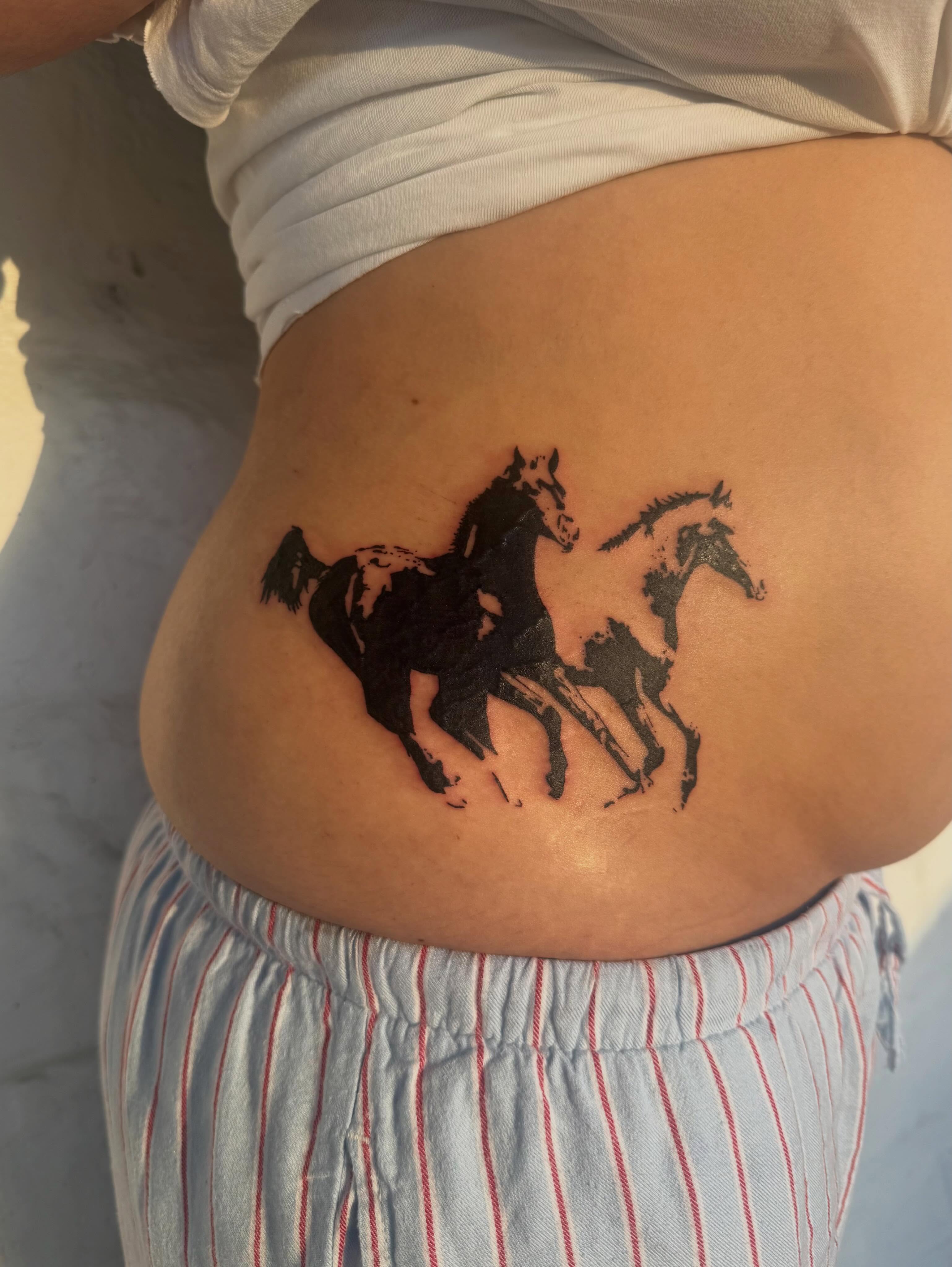 Horses black and grey tattoo on the torso by sarah