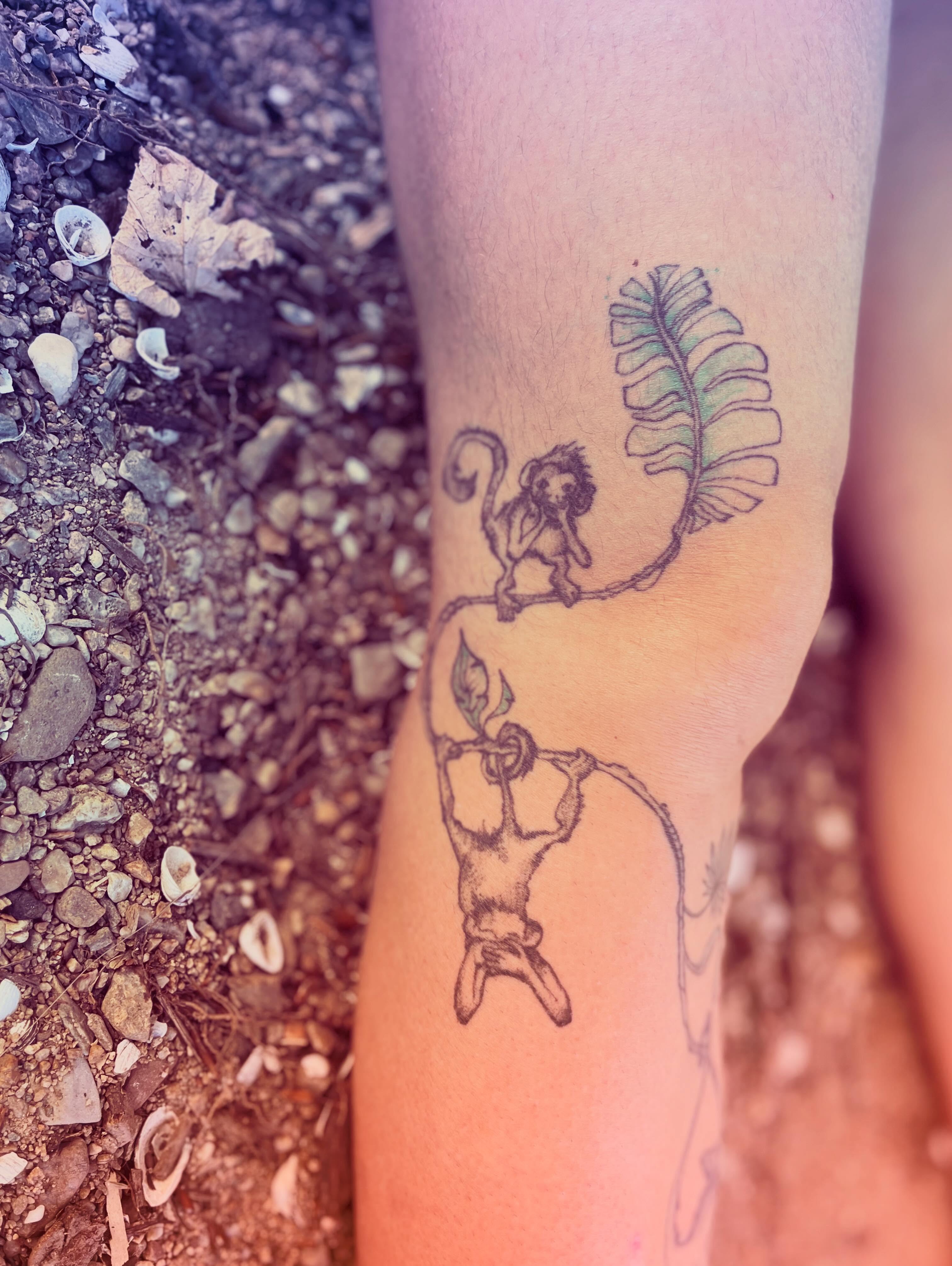 Monkey and leaf black and grey tattoo on the forearm by La Main Bleue