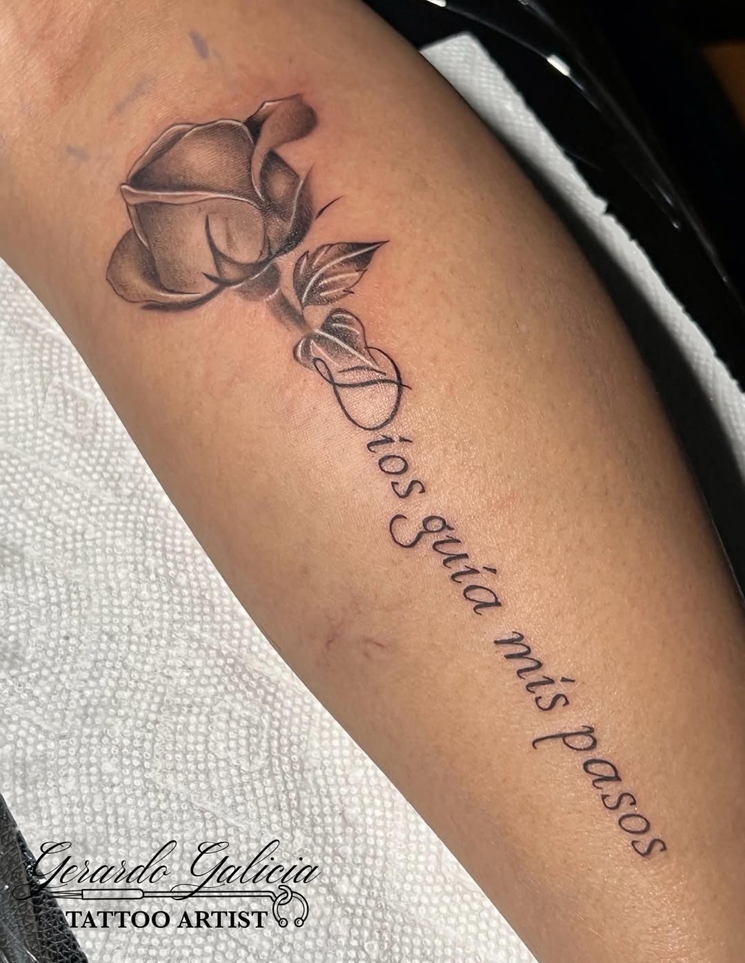 Rose and script lettering tattoo on the forearm by Gerardo Galicia, New York, New York