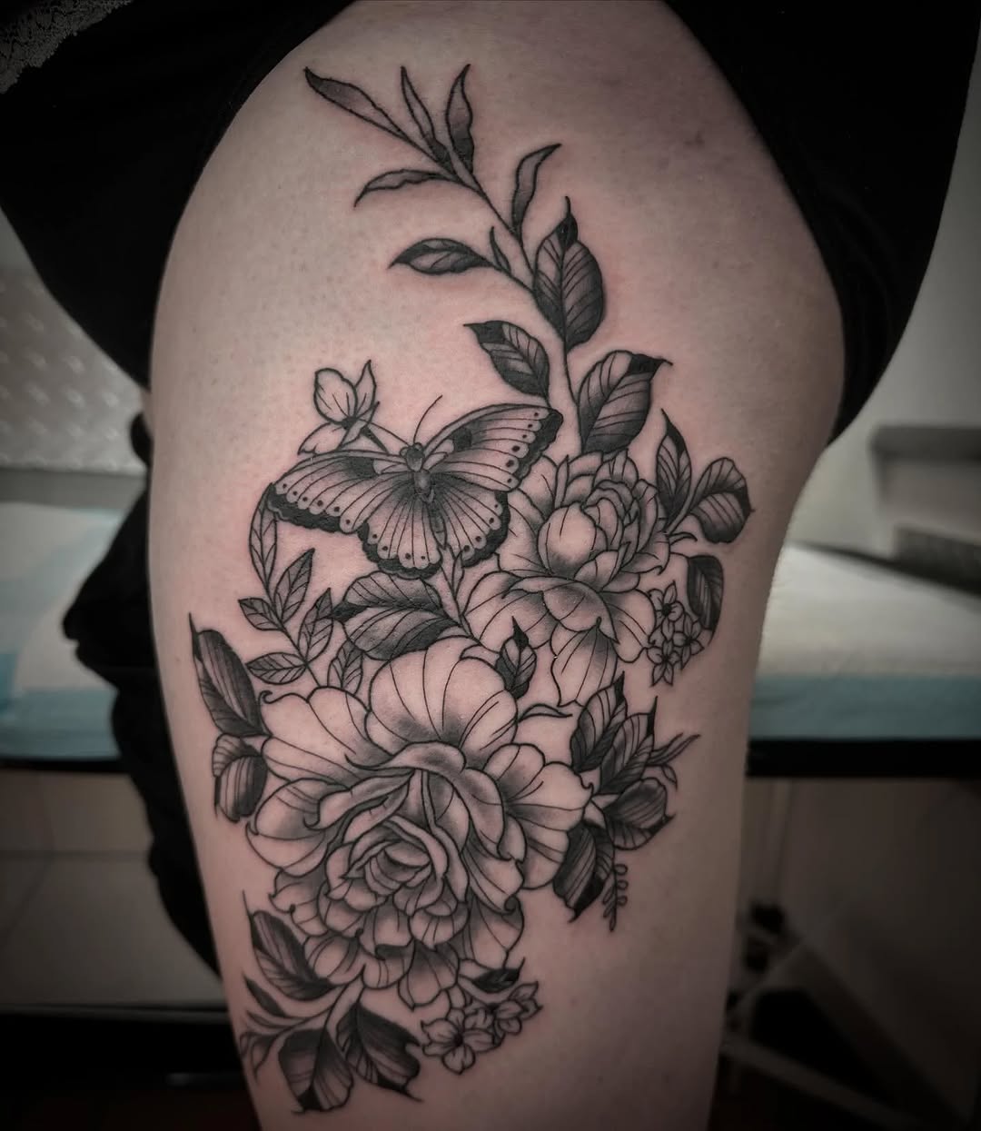 Butterfly and flowers dotwork tattoo on the thigh by Murl Dietrich