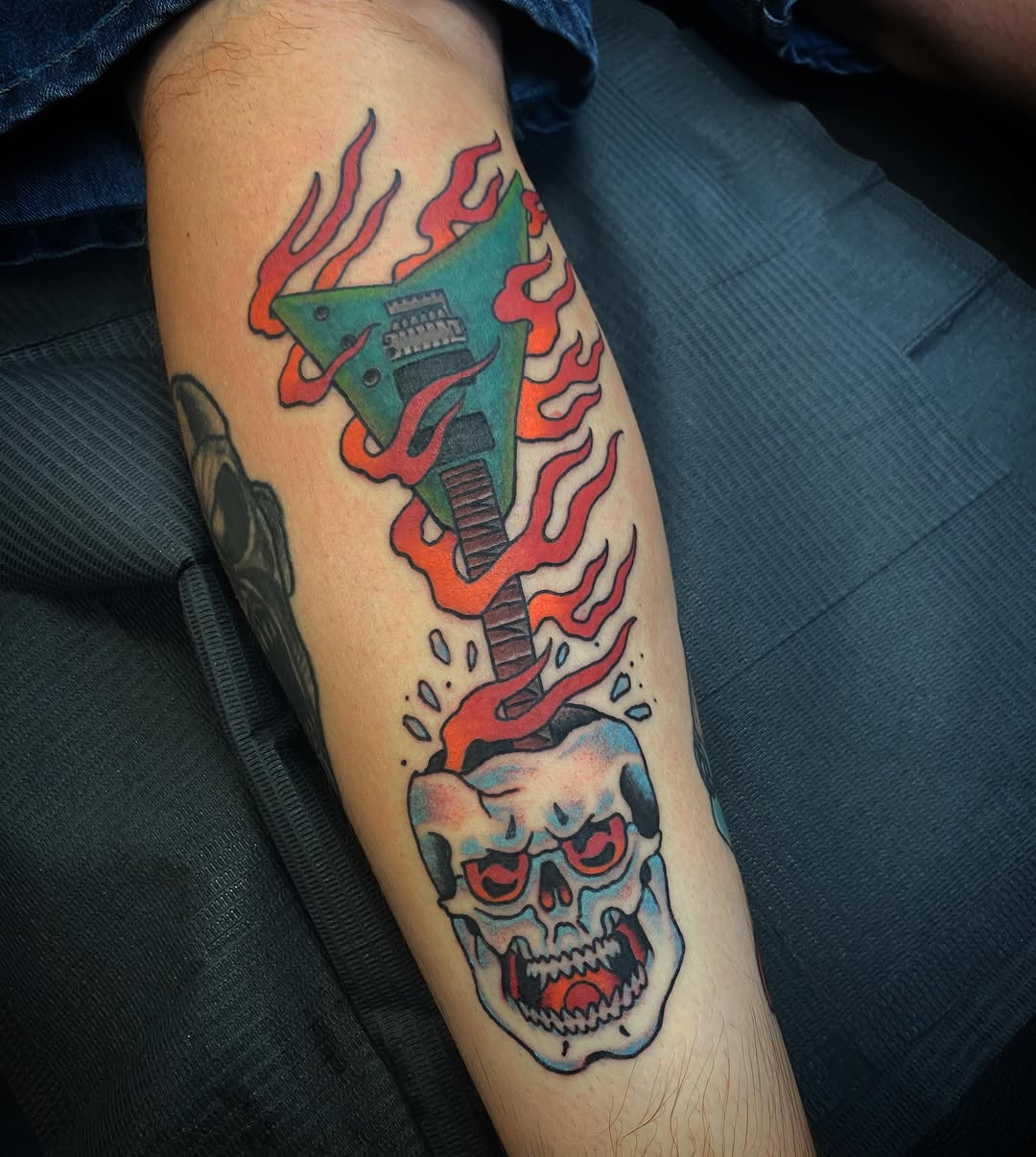 Guitar and skull American traditional tattoo on the forearm by Kyle Mitchell, Cincinnati
