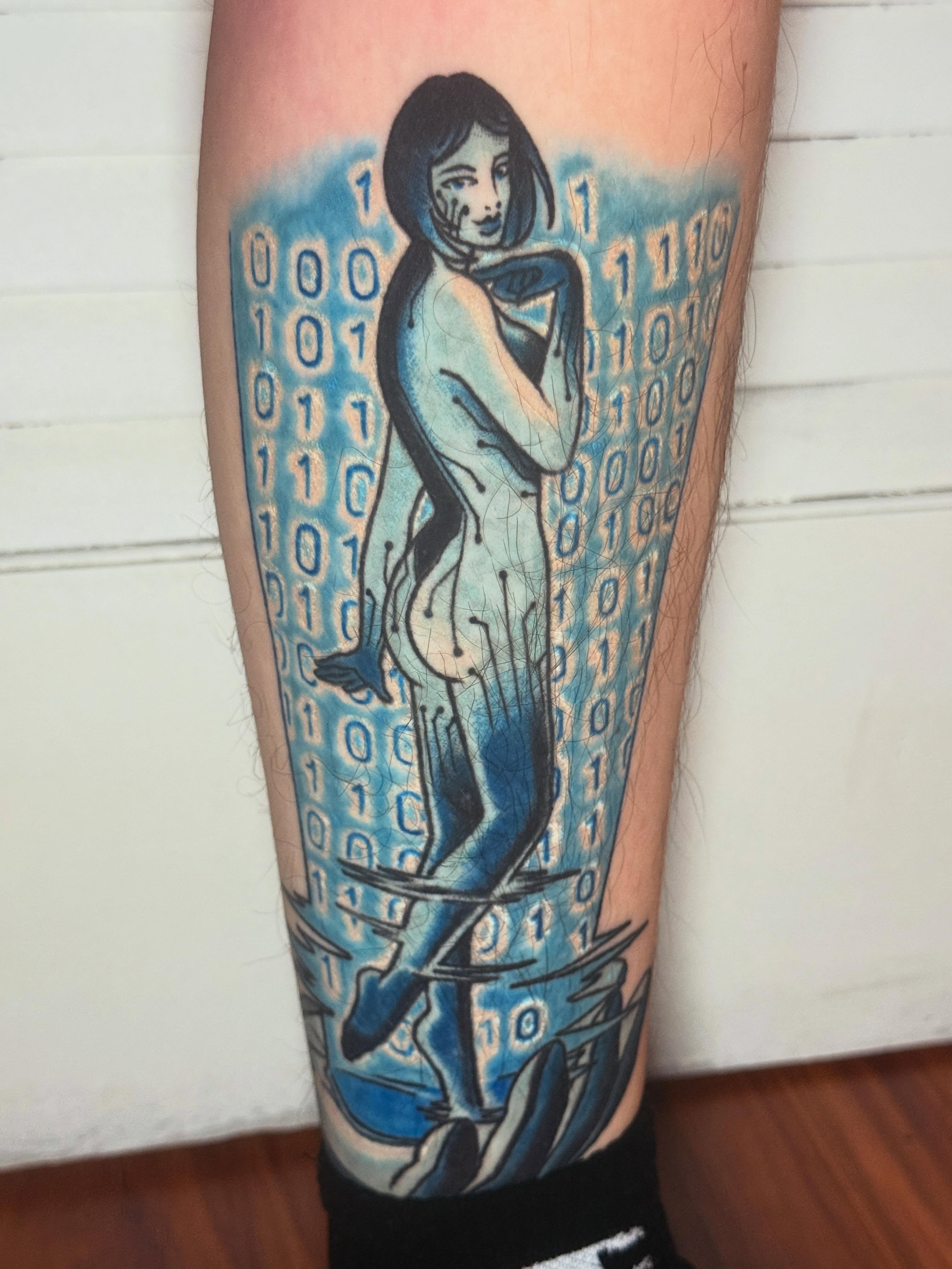 Nude woman with binary code illustrative tattoo on the calf by Cassie O'Neal DeBord