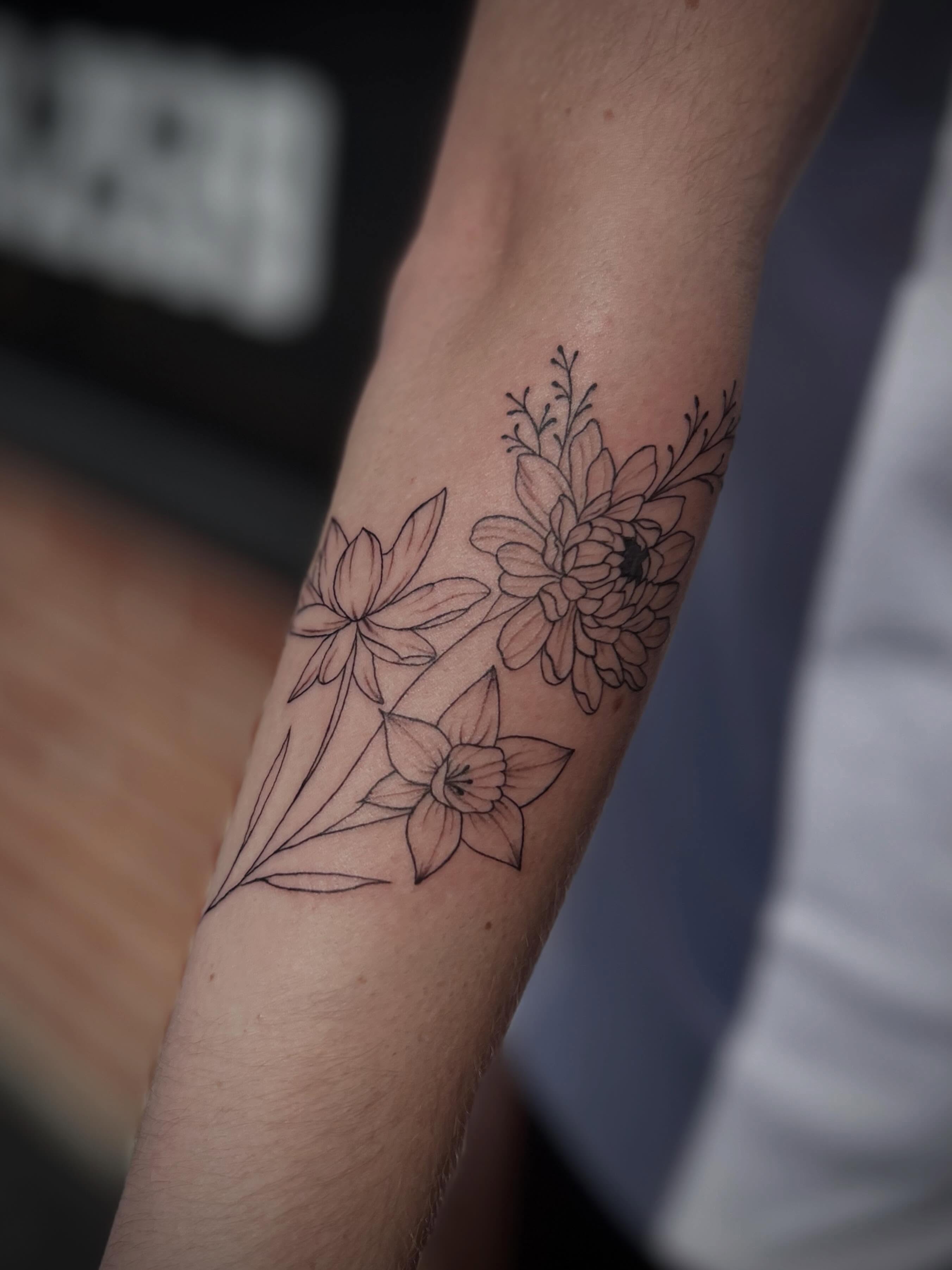 Floral arrangement black and grey tattoo on the forearm by Lexi Rose