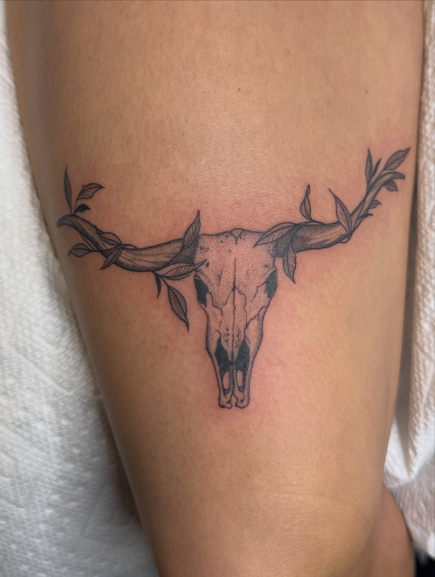 Bull skull with leaves black and grey tattoo on the thigh by WhoisLaineyTattoos
