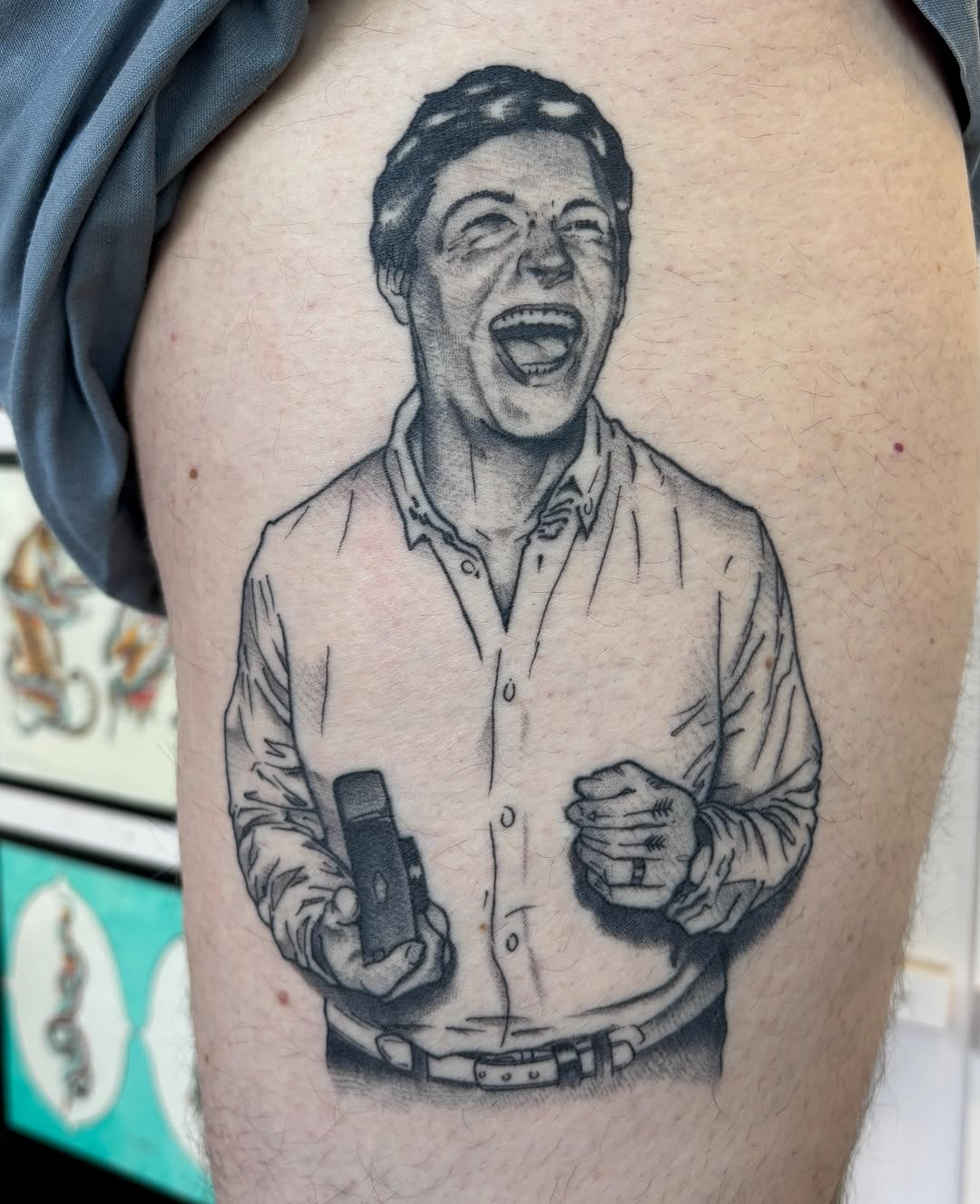 Man laughing with a microphone surrealism tattoo on the thigh by Amelia Rose, Los Angeles, California