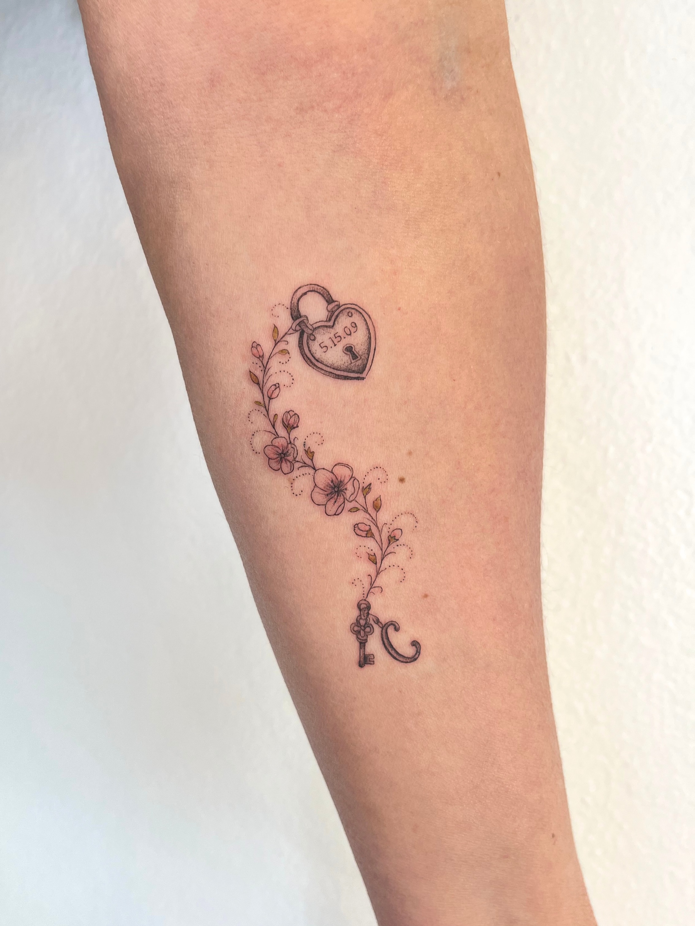 Heart and key black and grey tattoo on the forearm by kt