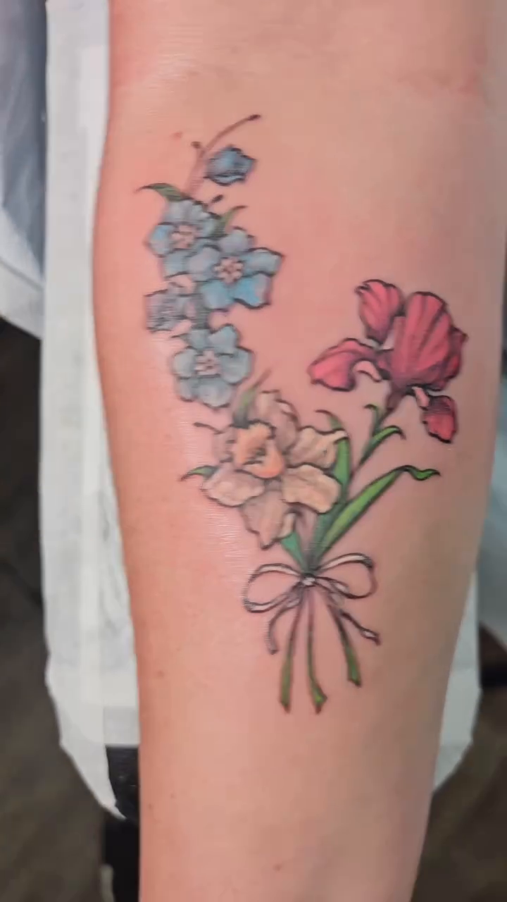 Bouquet of flowers with a bow watercolor tattoo on the forearm by The Fabled Tattooist (Alyssa Summers), Eagle Point, Oregon