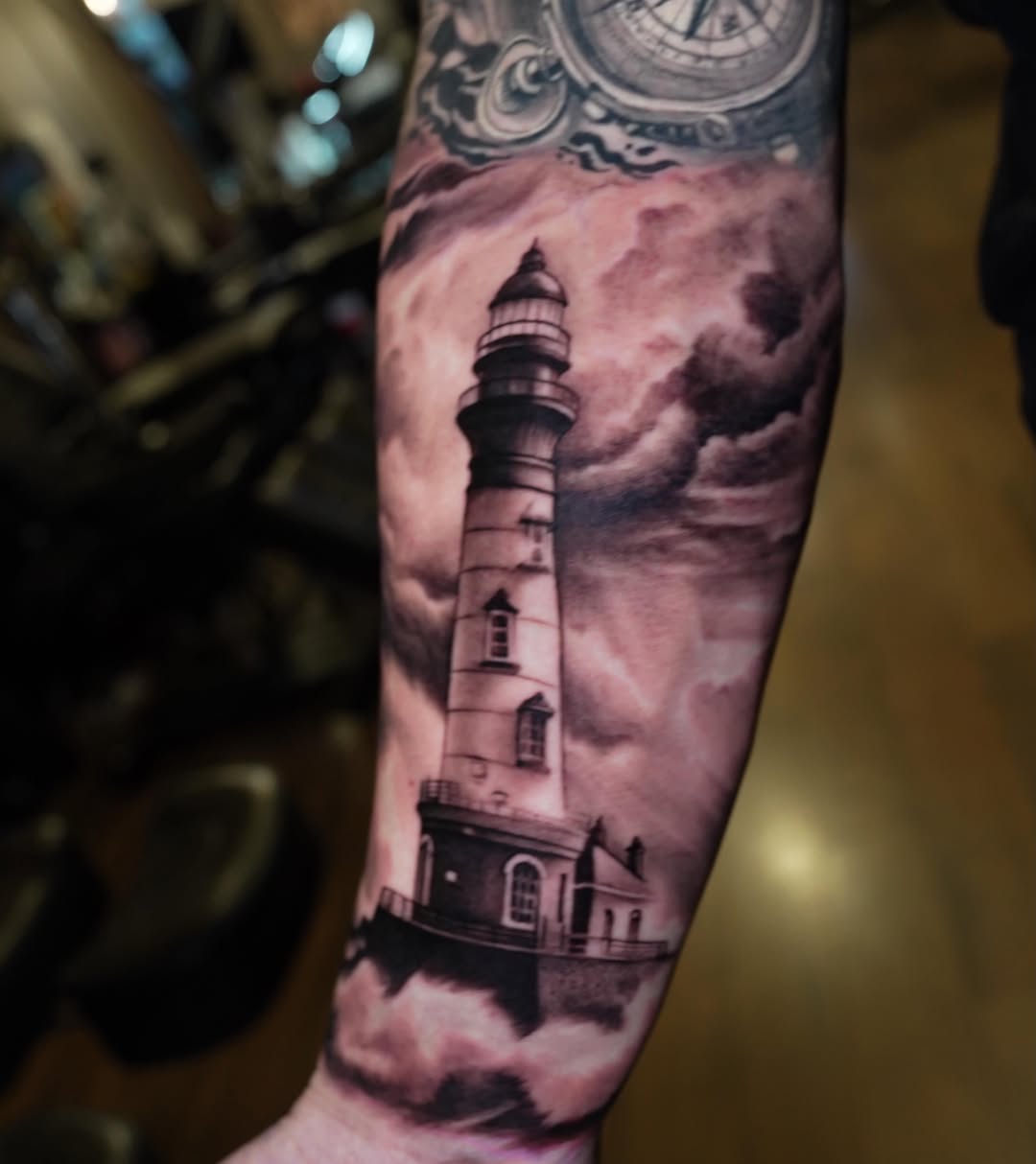 Lighthouse in stormy seas surrealism tattoo on the forearm by Erick Satchell II