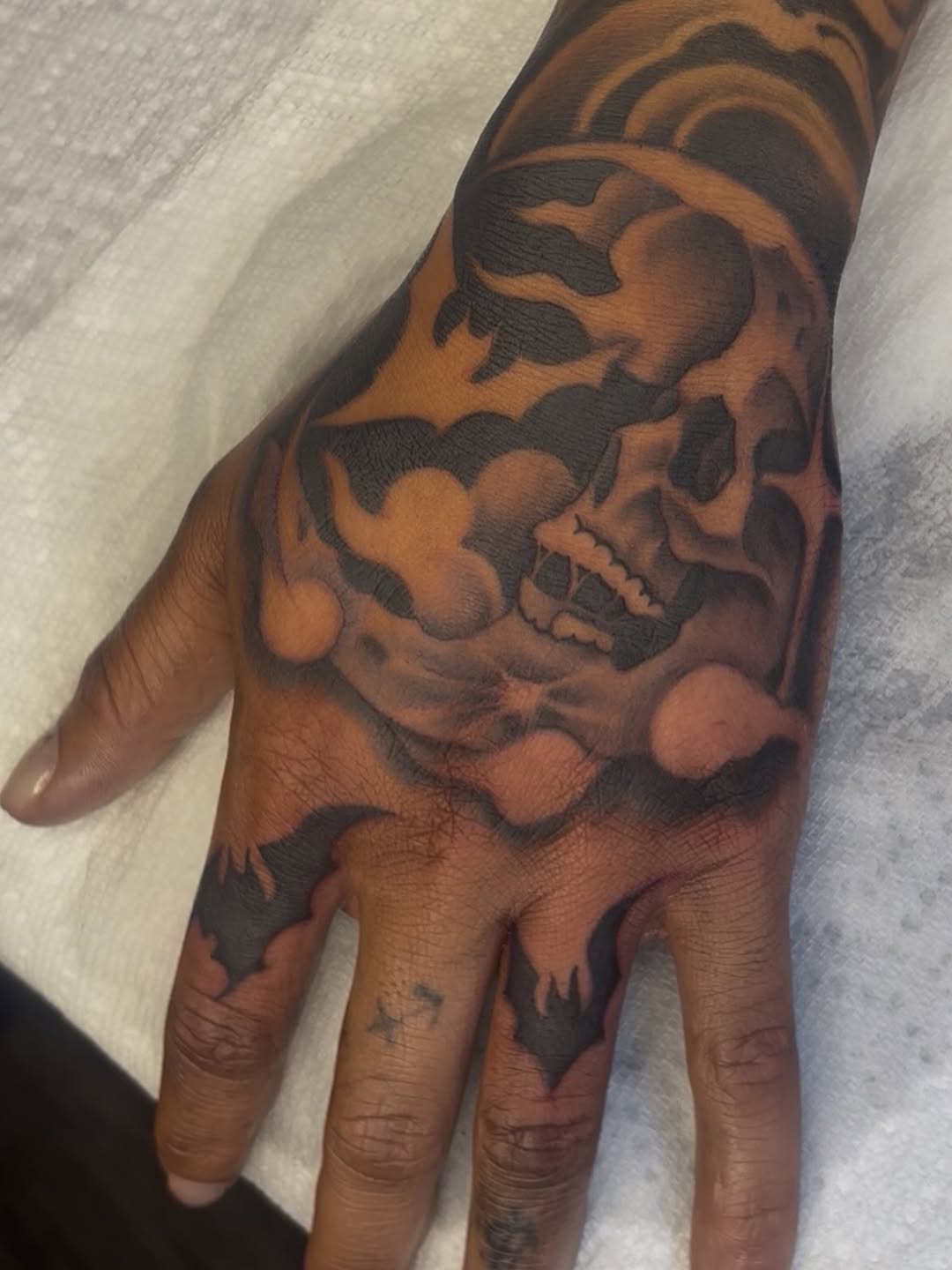 Skull and bats realism tattoo on the hand by Terrence jones