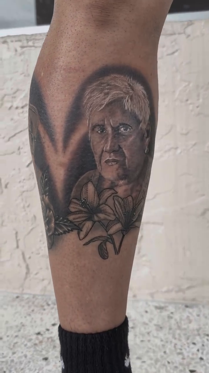Portrait of a man with flowers realism tattoo on the foot by Raciel Fabian Romero