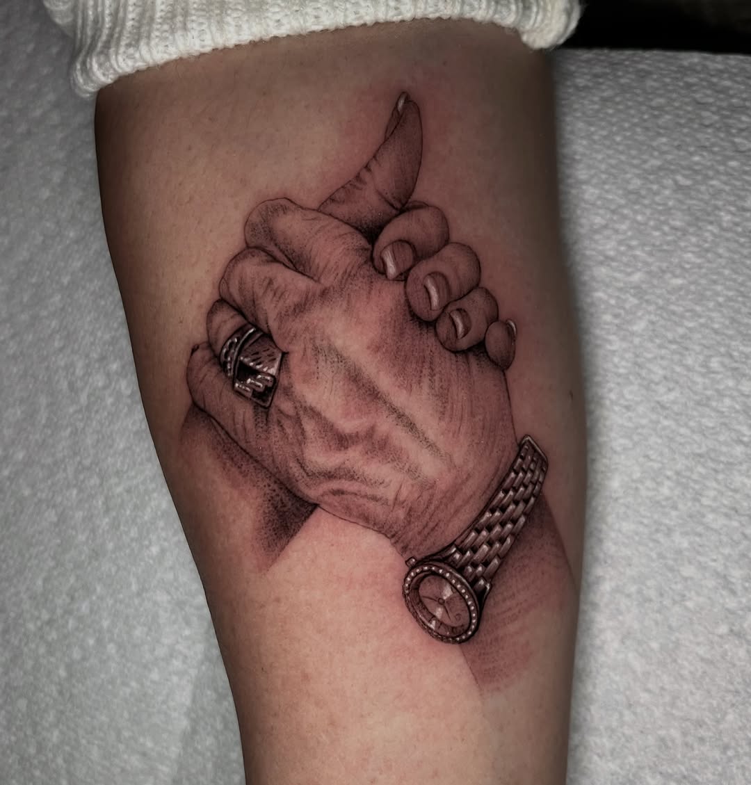 Interlocking hands with watch and ring Chicano tattoo on the forearm by Single Needle ๐ชฉ