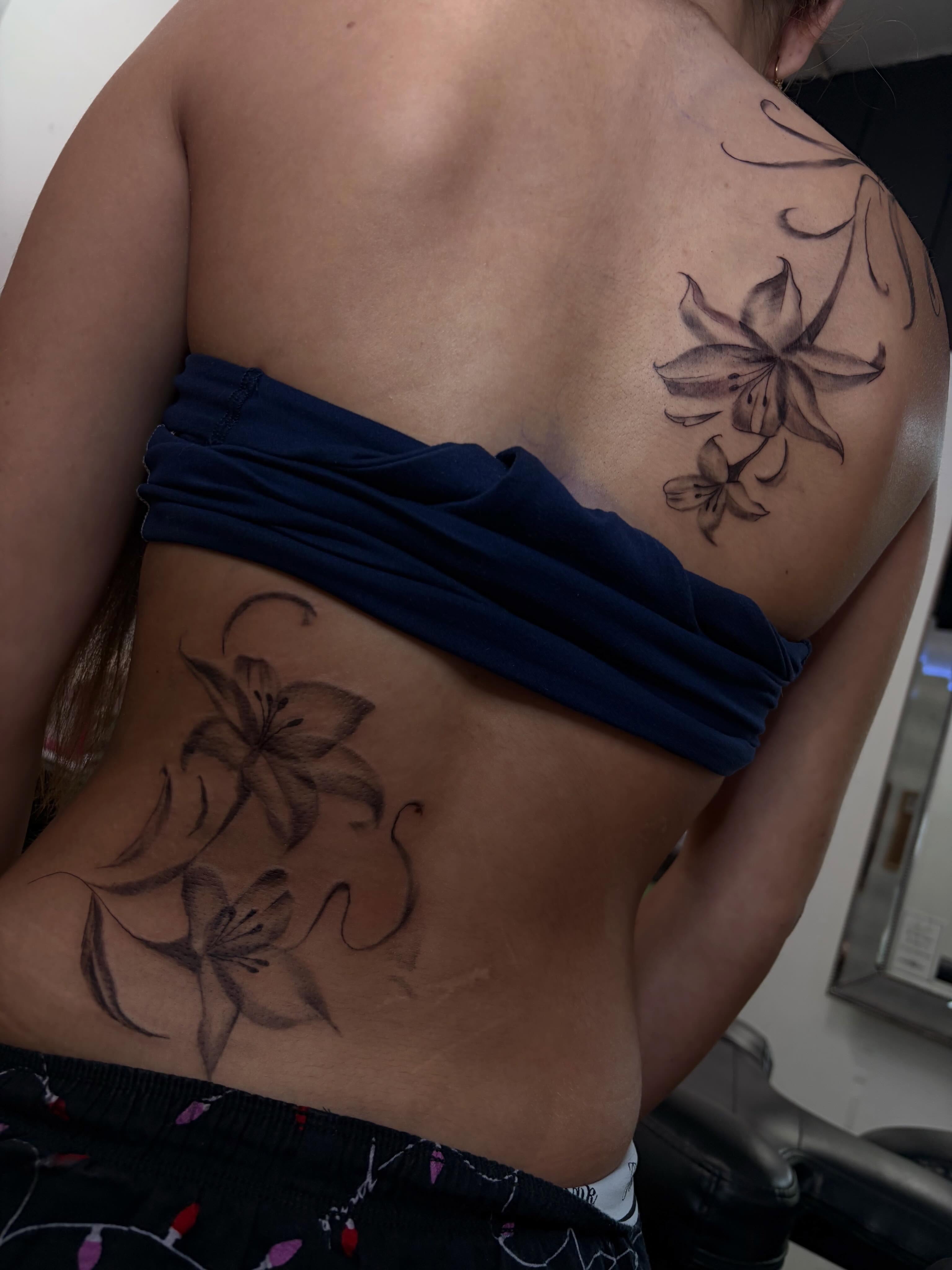 Lily flowers black and grey tattoo on the torso by Cincinnati Tattoo Artist