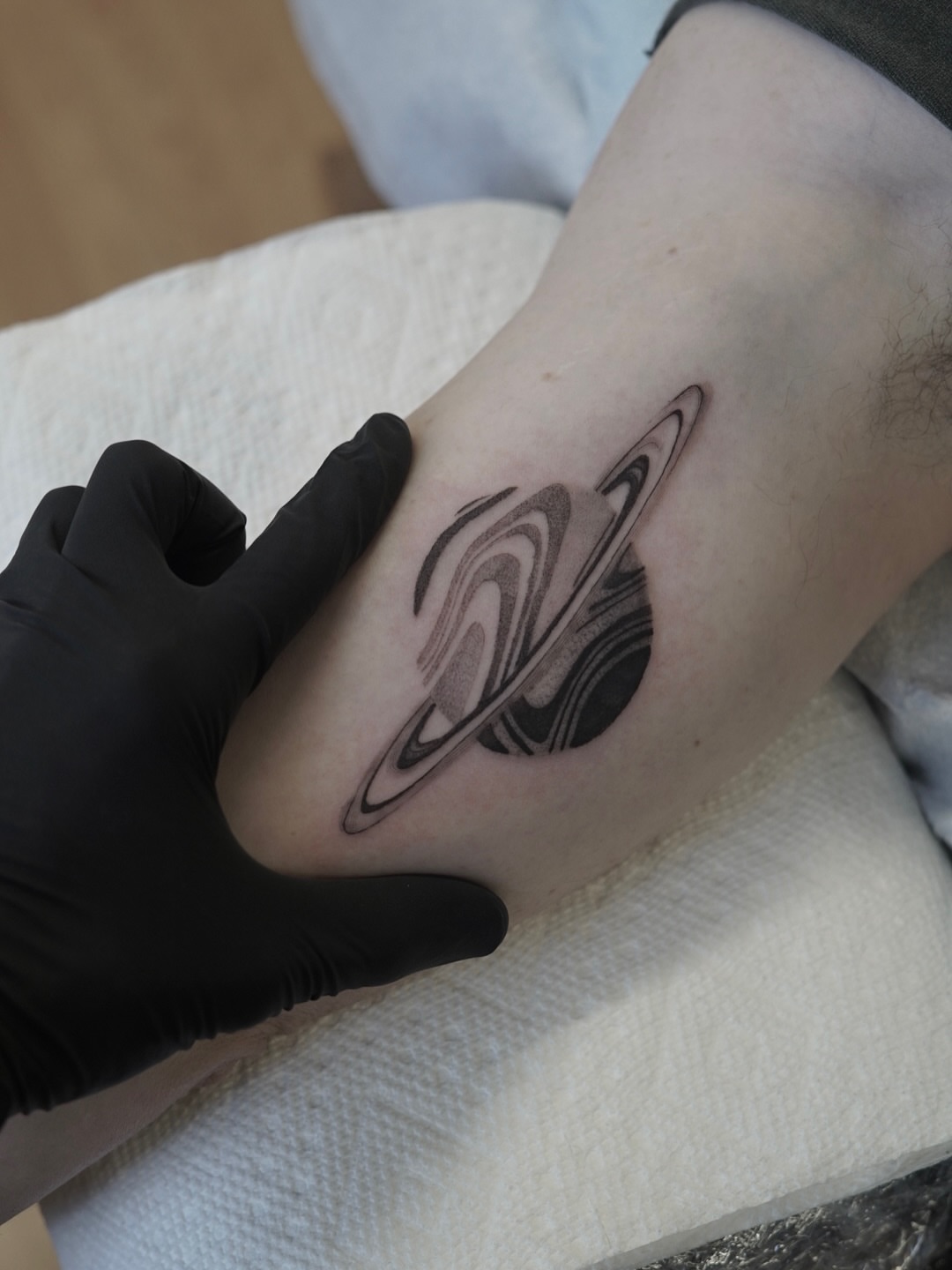 Saturn black and grey tattoo on the forearm by Josh Infante