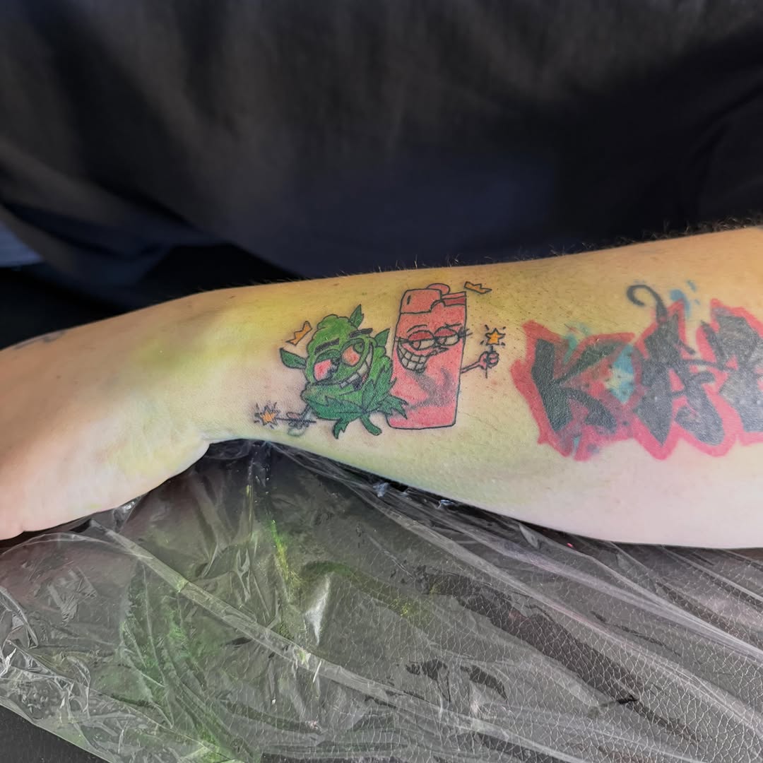 Marijuana bud and lighter characters new school tattoo on the forearm by Jay