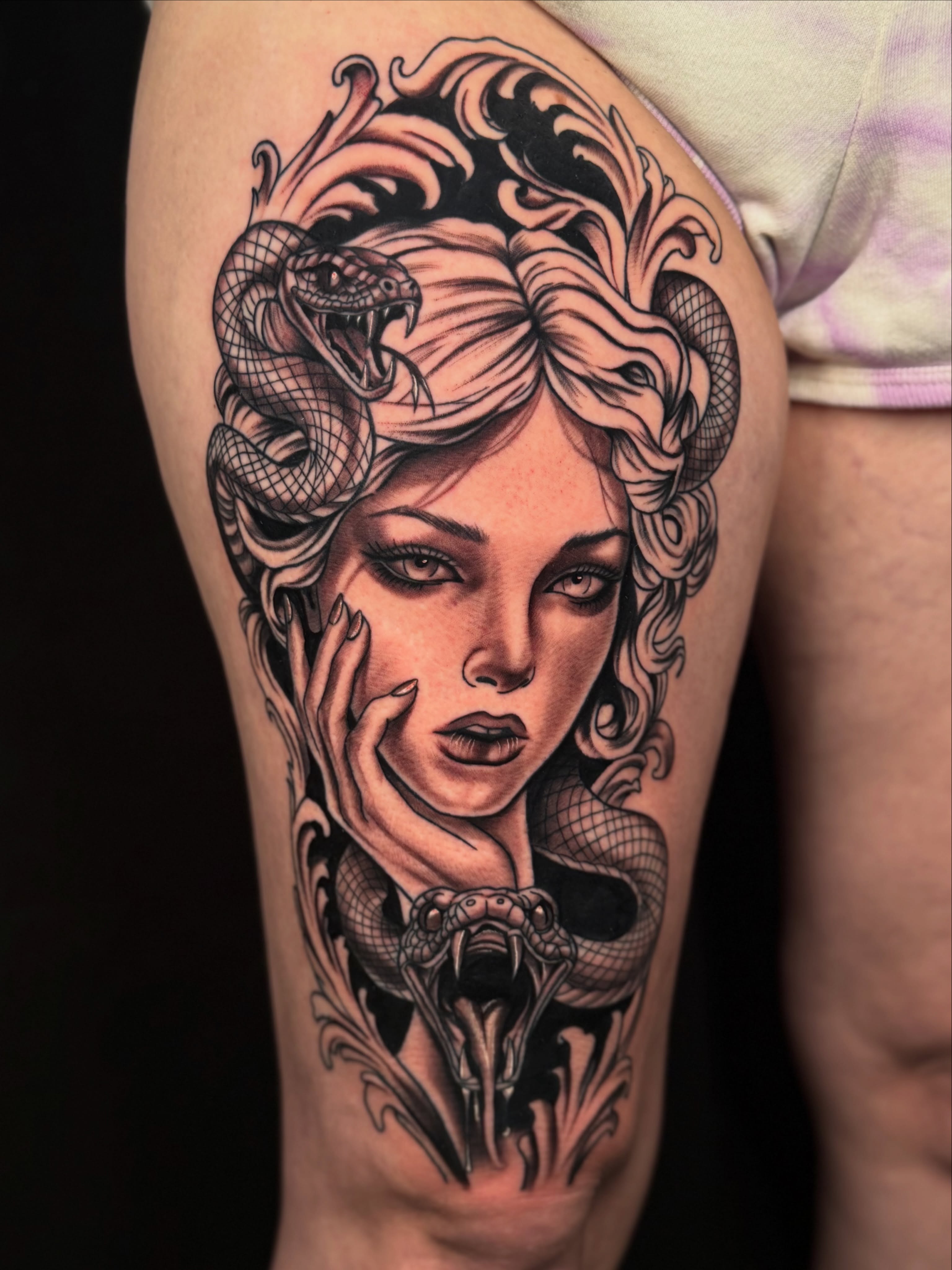 Woman with snakes realism tattoo on the thigh by Tevin Thomas
