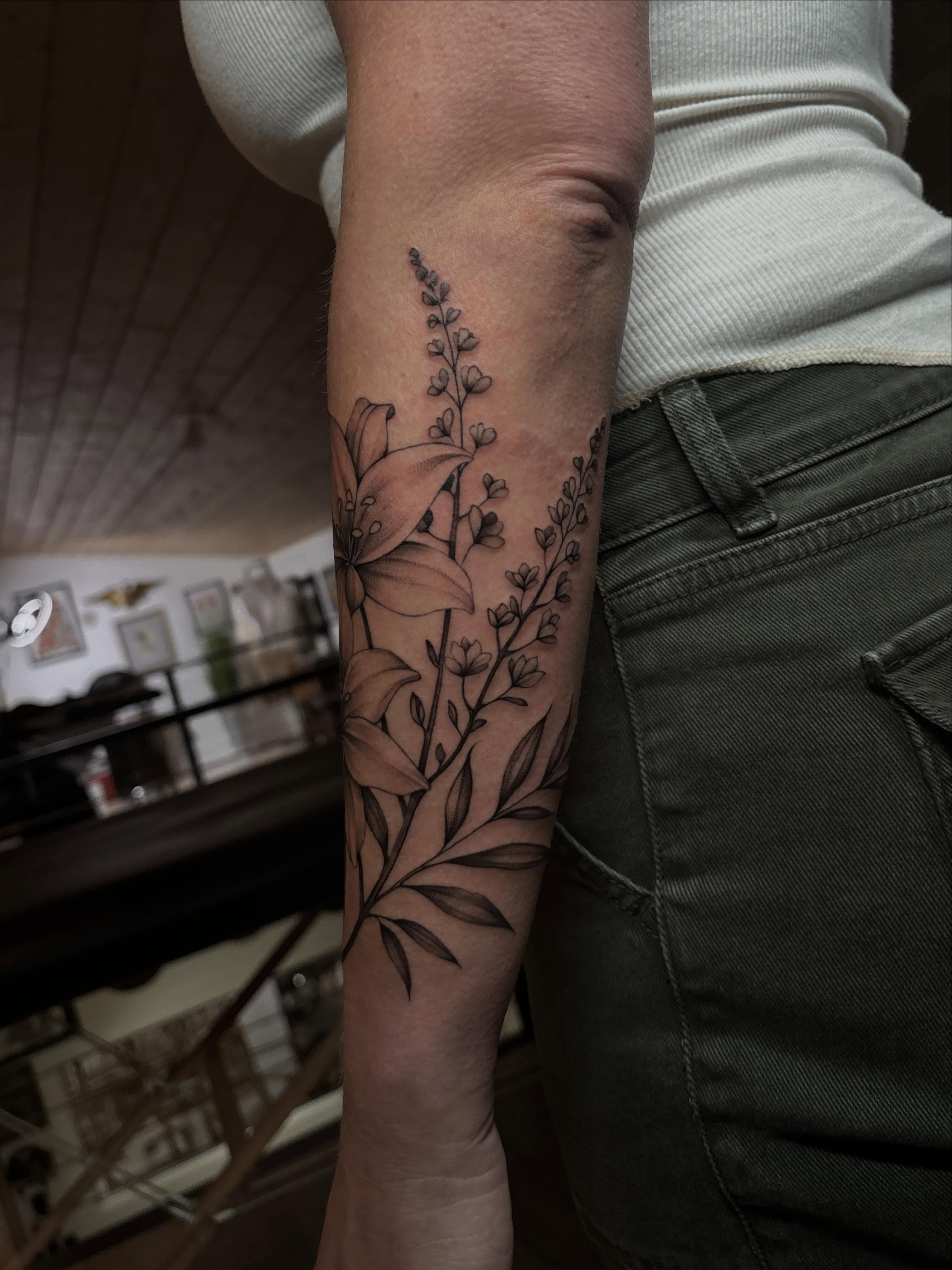Floral arrangement black and grey tattoo on the forearm by Emma Cotter