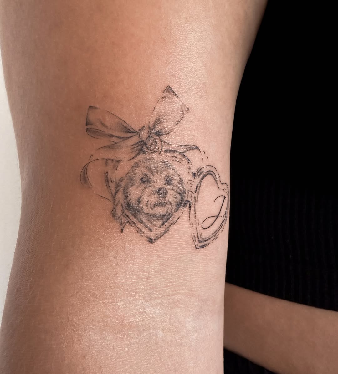 Dog portrait with locket and bow realism tattoo on the forearm by Helly March
