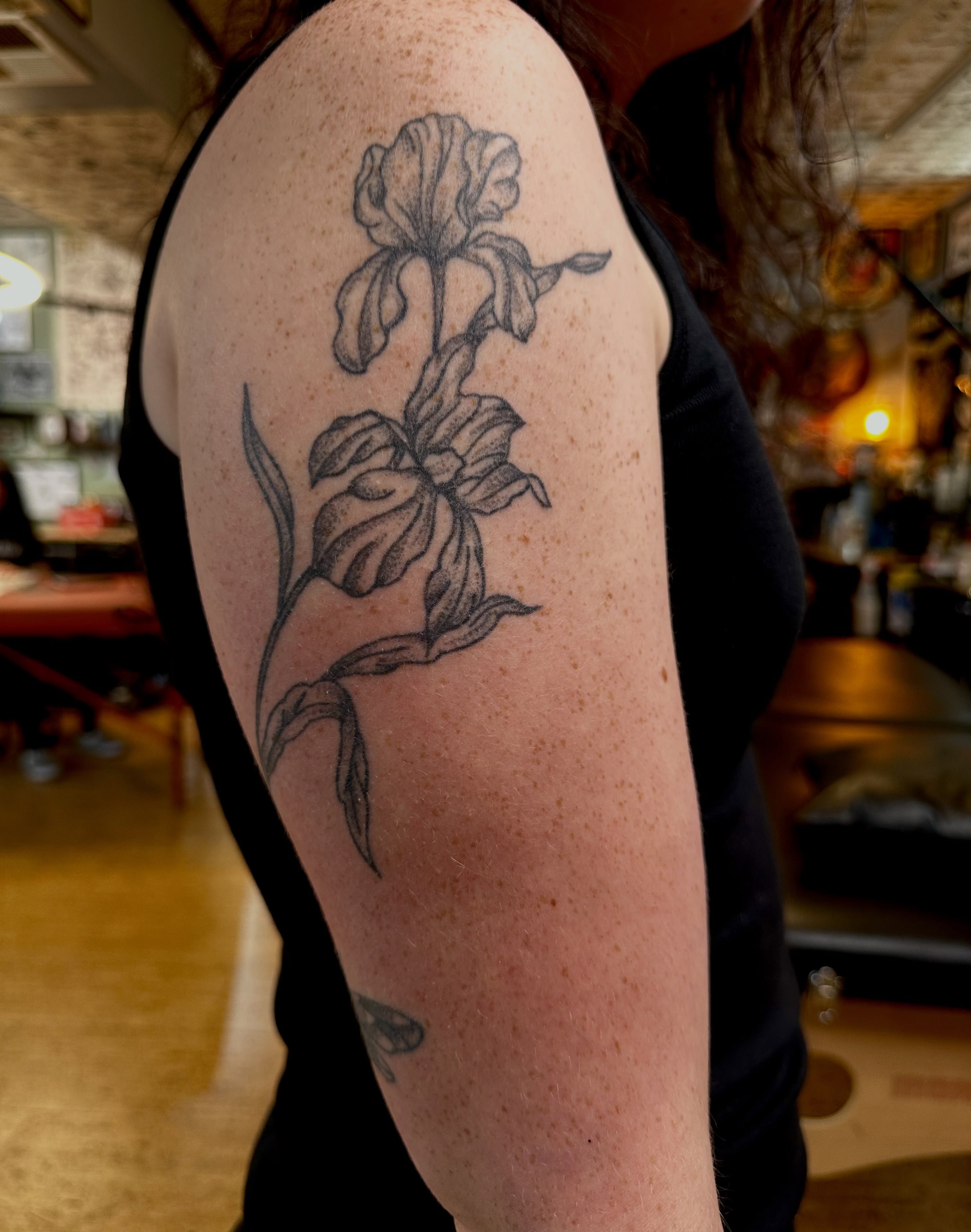 Iris black and grey tattoo on the upper arm by teddy, Portland, Oregon