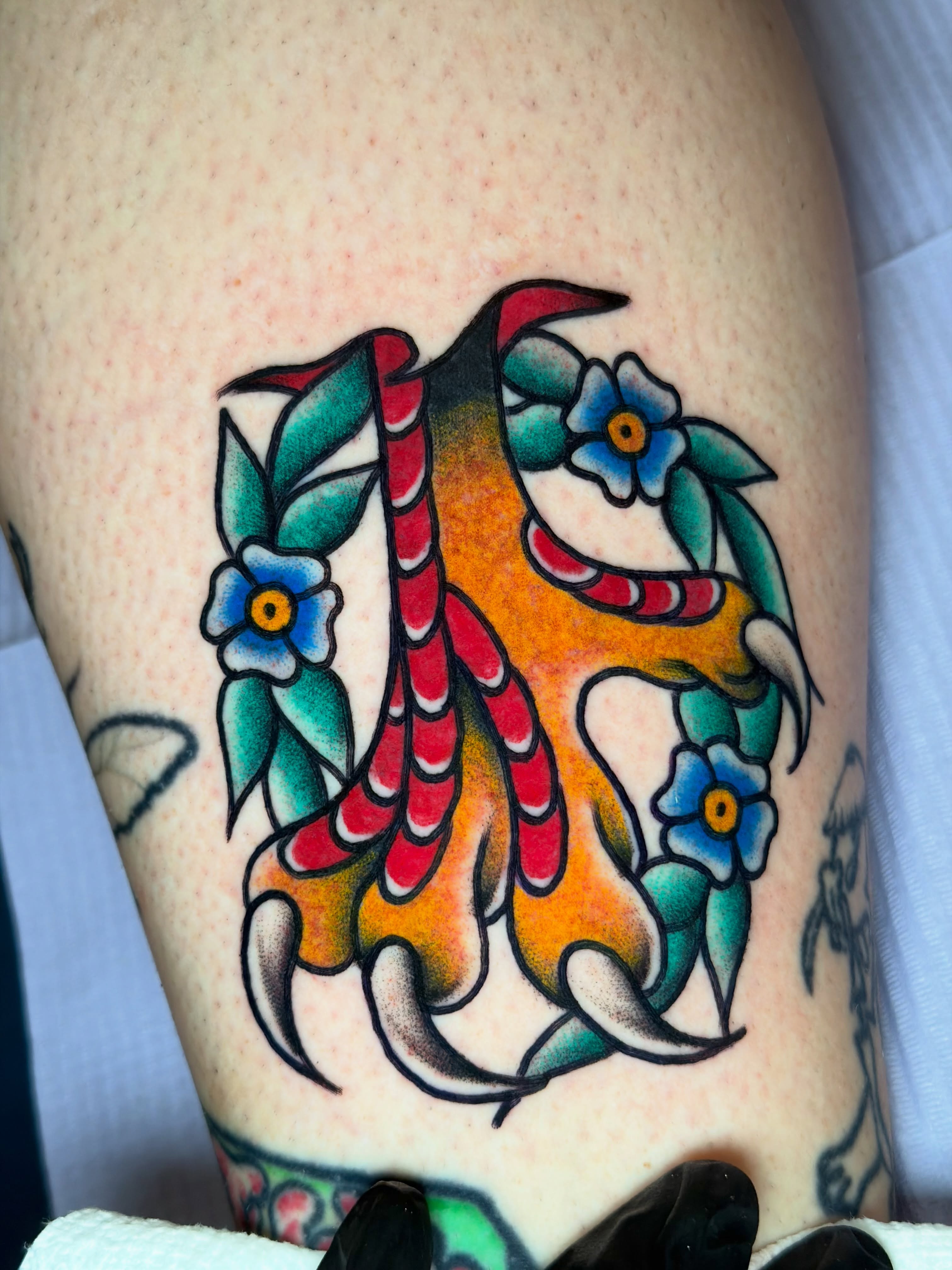 Fish and flowers American traditional tattoo on the thigh by @ryanpereztattoo