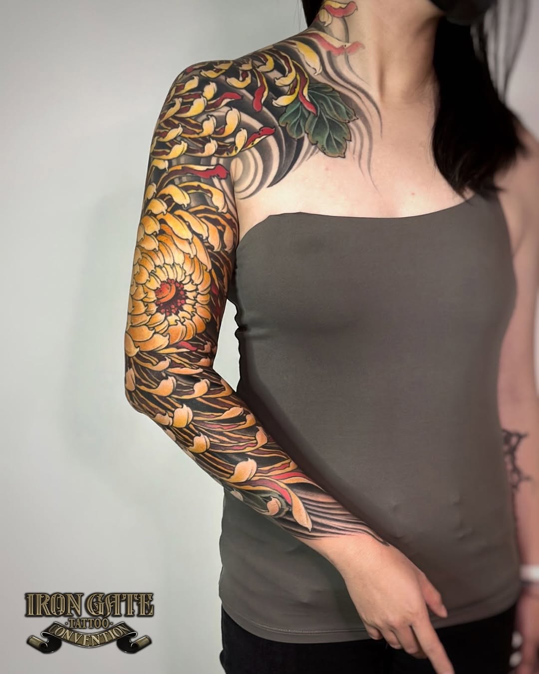 Chrysanthemum and waves Japanese tattoo on the upper arm by Scienz 九卦刺青