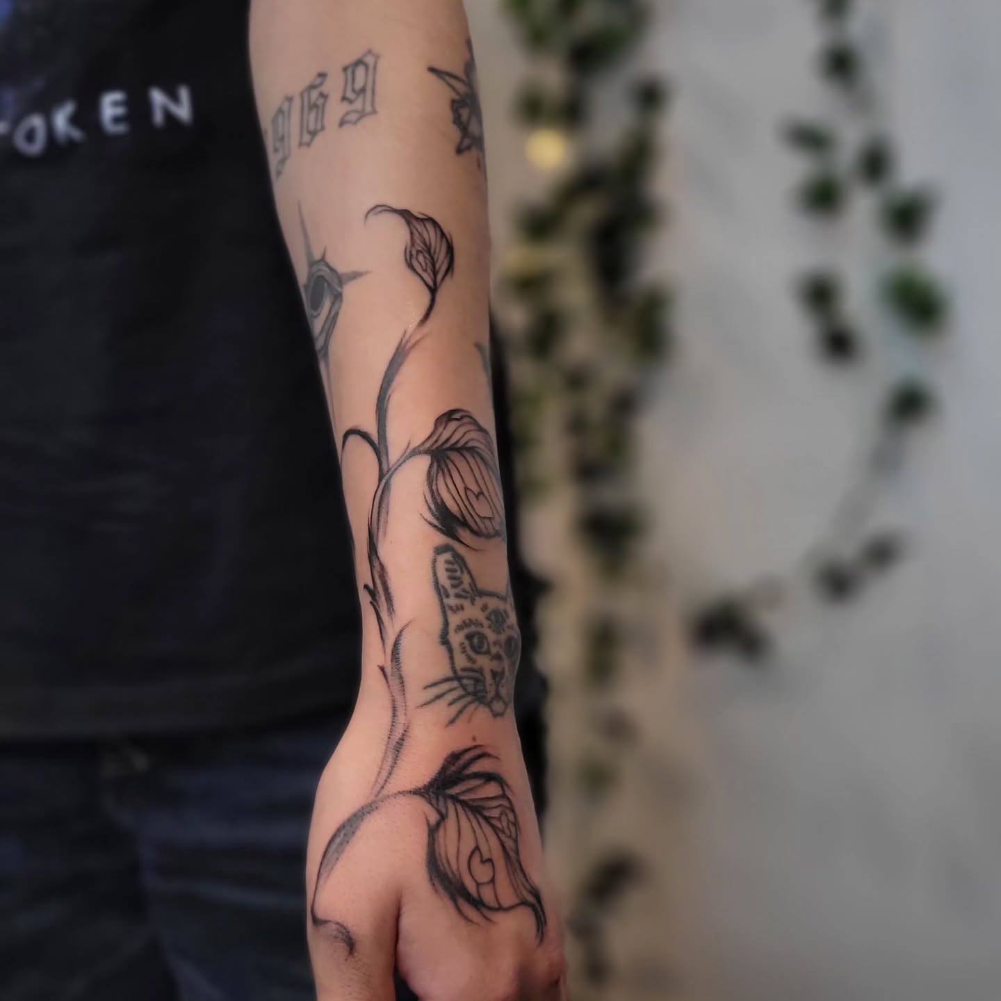 Cat and floral vine realism tattoo on the forearm by Uku Tattoos, Cambridge, England