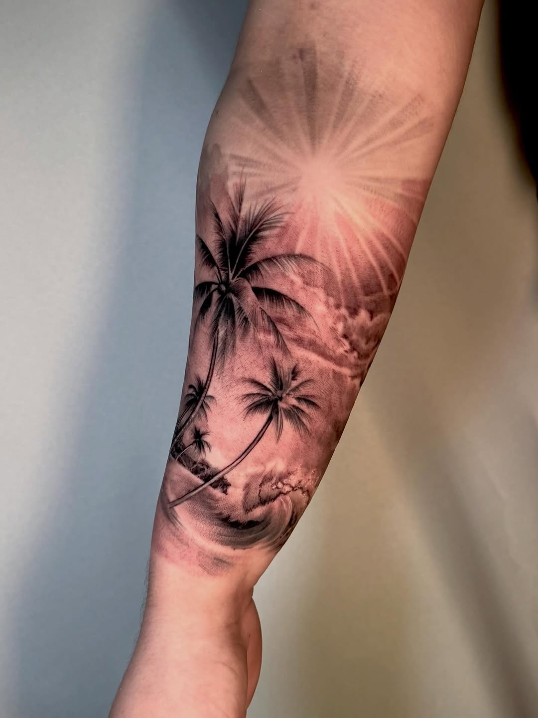 Palm trees and ocean wave realism tattoo on the forearm by Joi Bailey, Denton, Texas