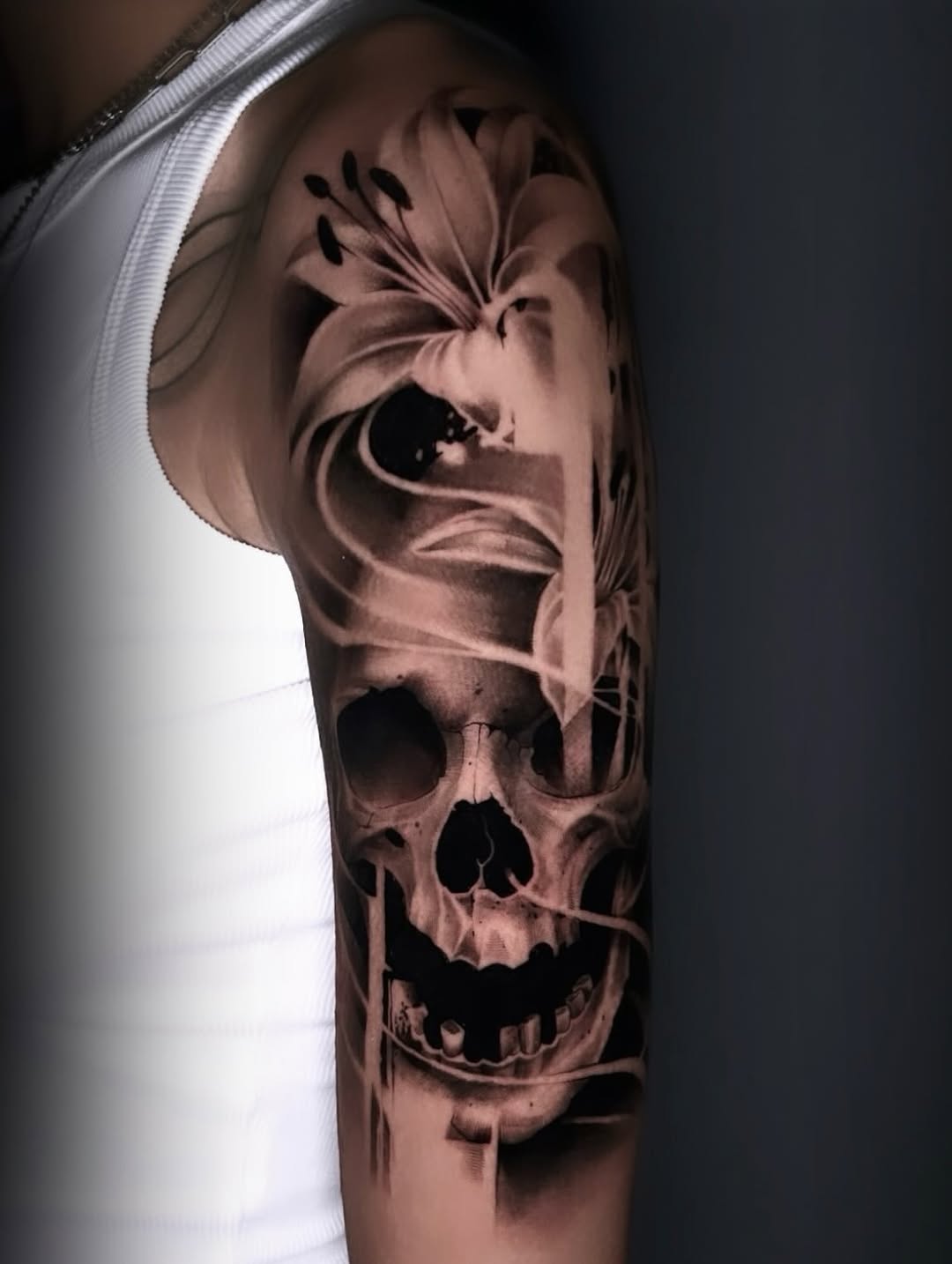 Skull and lilies realism tattoo on the forearm by Dallas Corsmeier