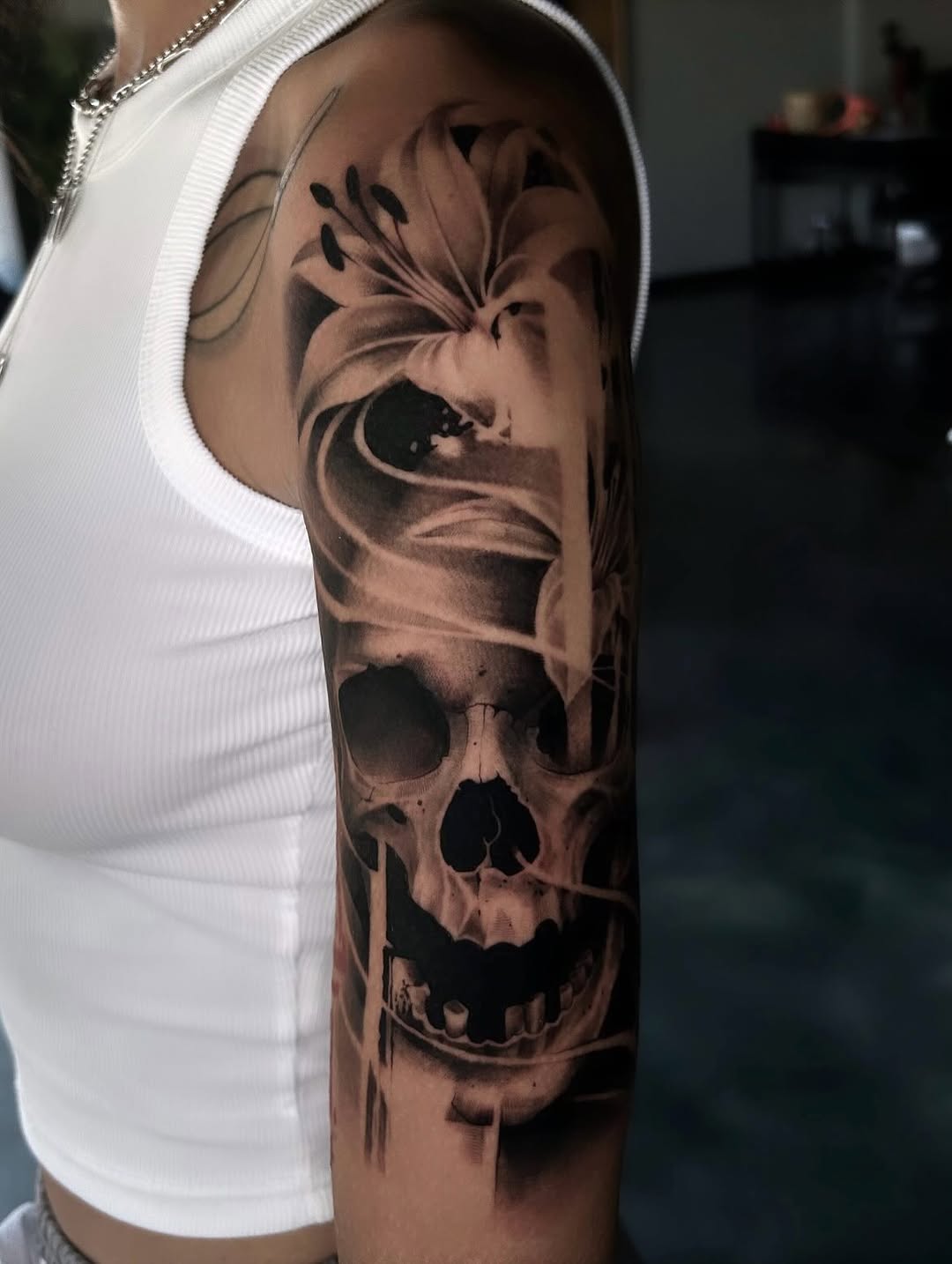 Skull and lily realism tattoo on the forearm by Dallas Corsmeier