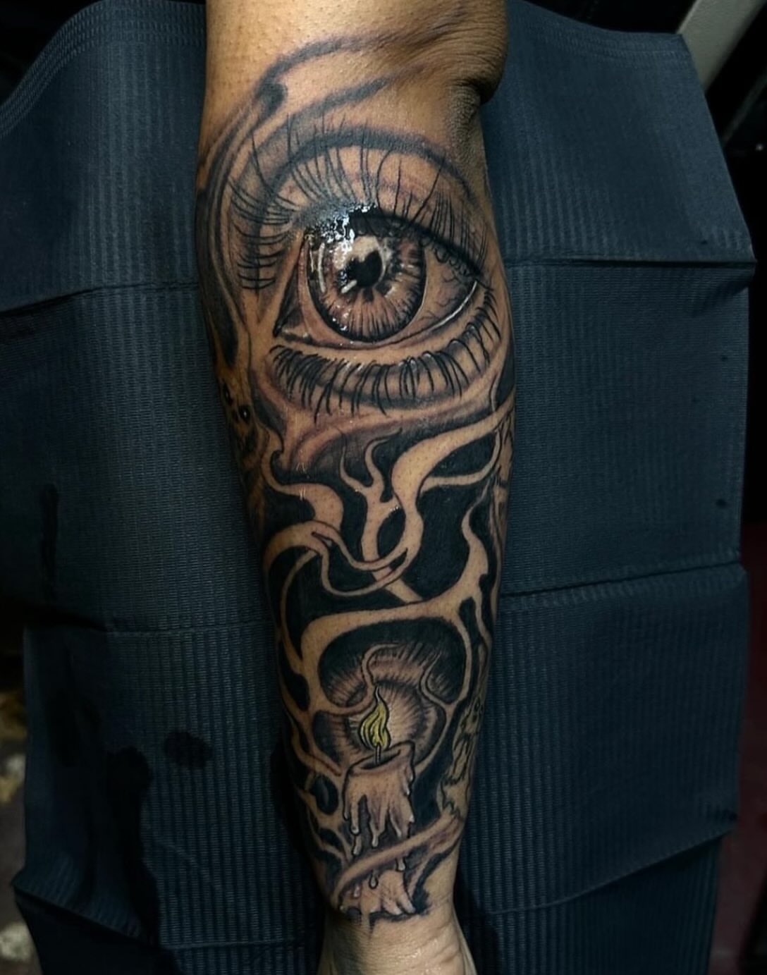 Eye and candle realism tattoo on the forearm by Gary Chase