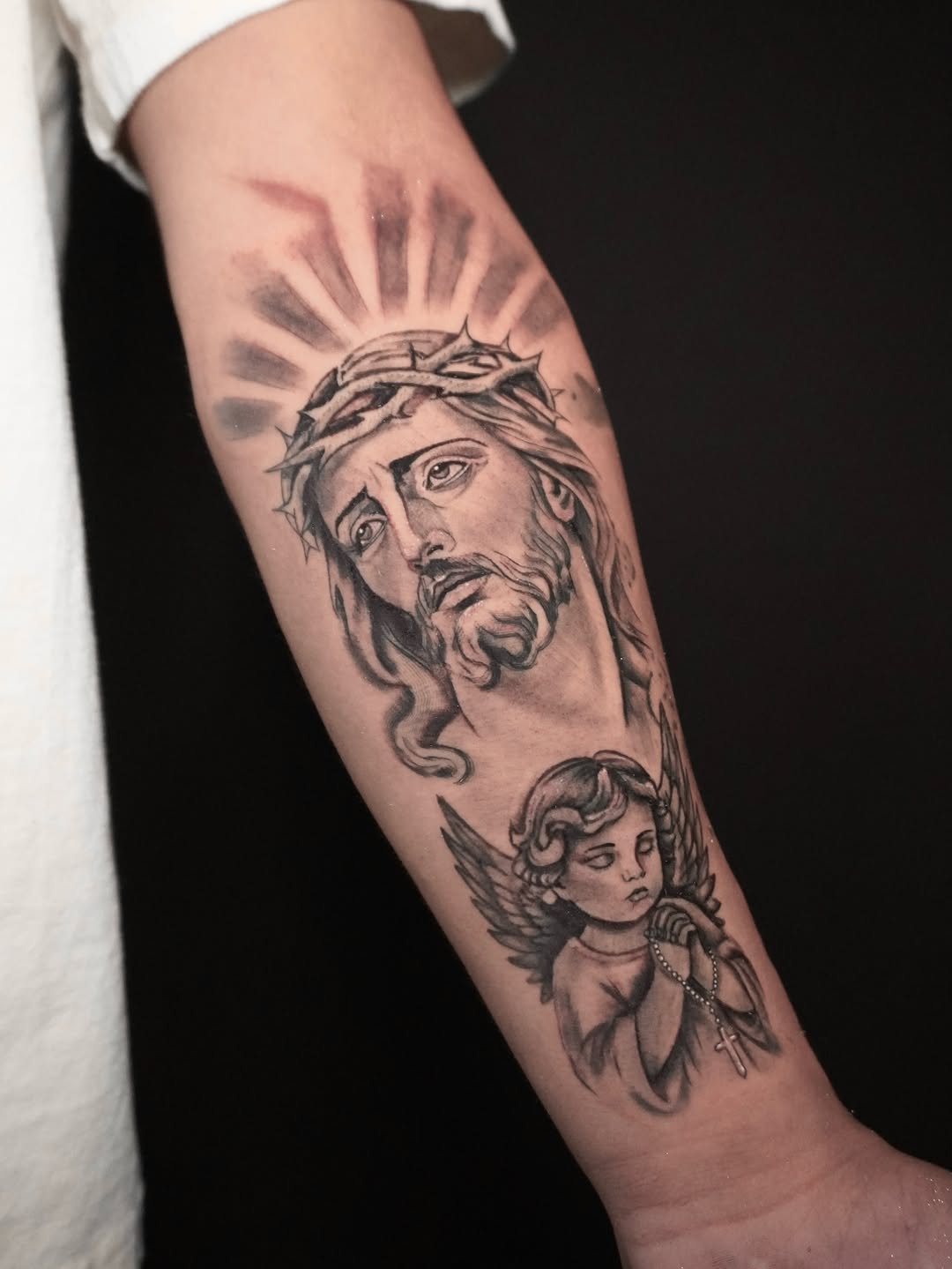 Jesus Christ and cherub realism tattoo on the forearm by Alex Cantor