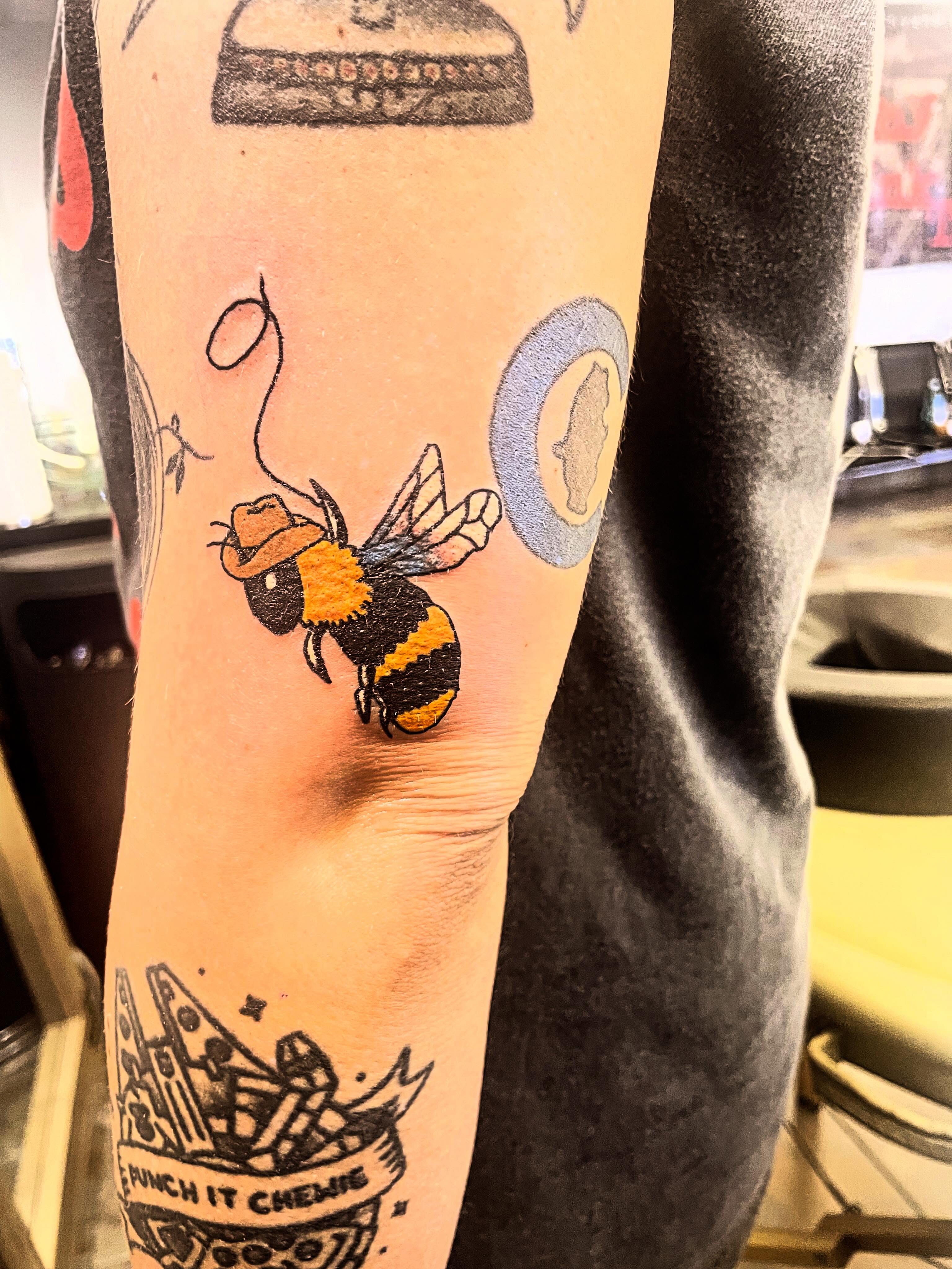 Bee wearing hat American traditional tattoo on the forearm by Stoney